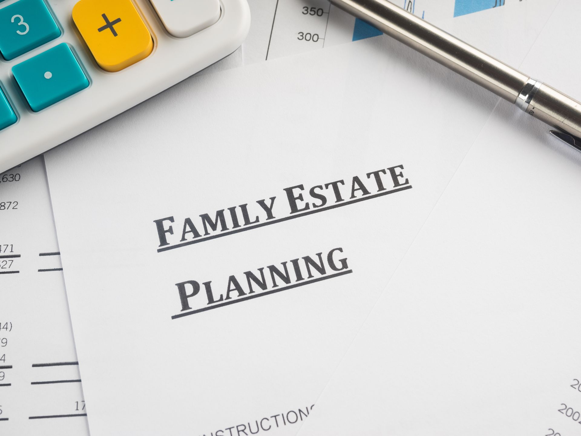 Family estate planning document with calculator and pen on a desk Family estate planning document with calculator and pen on a desk