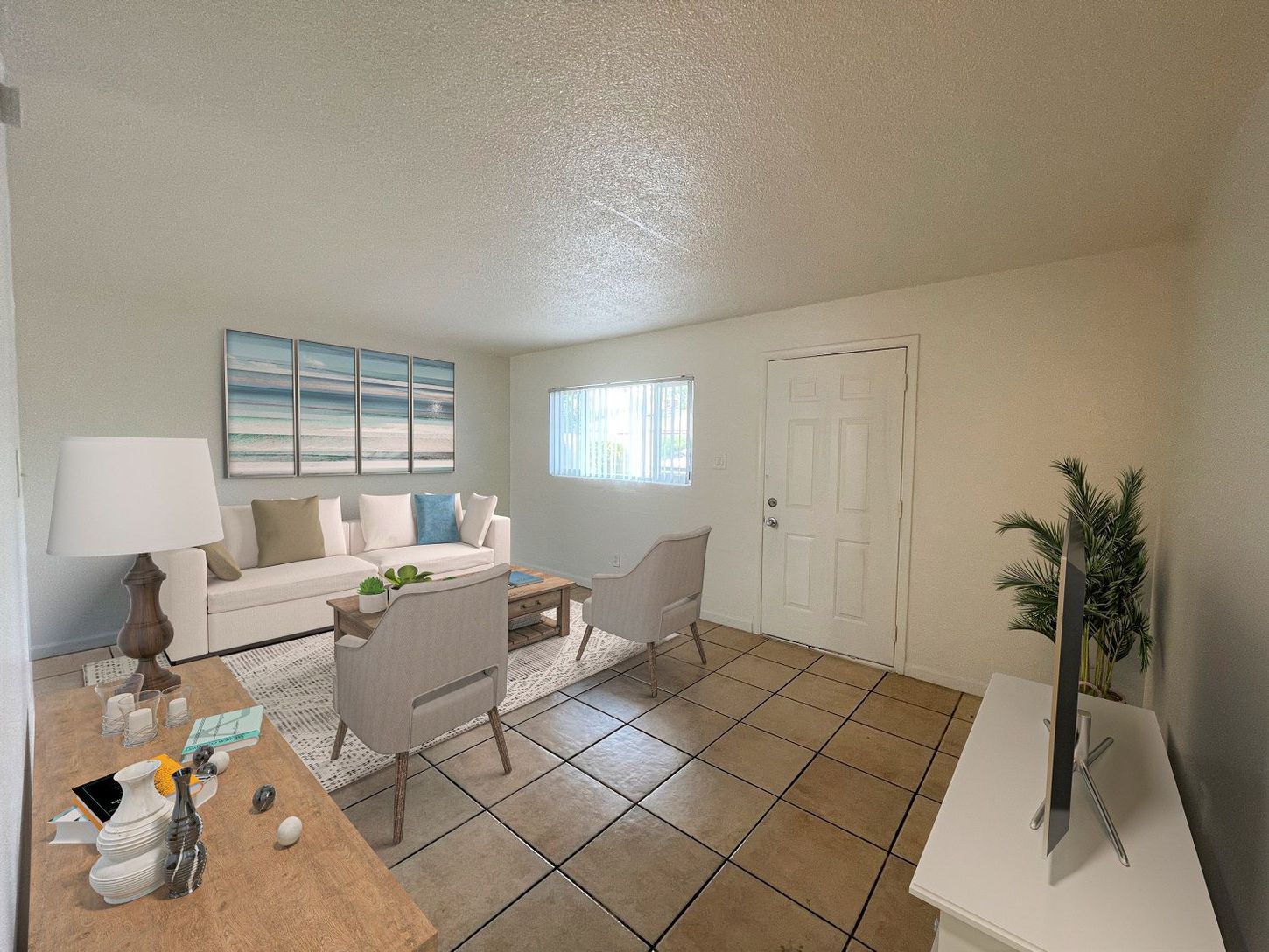 Living room with beige walls, tiled floor, white couch, and TV on a white stand.