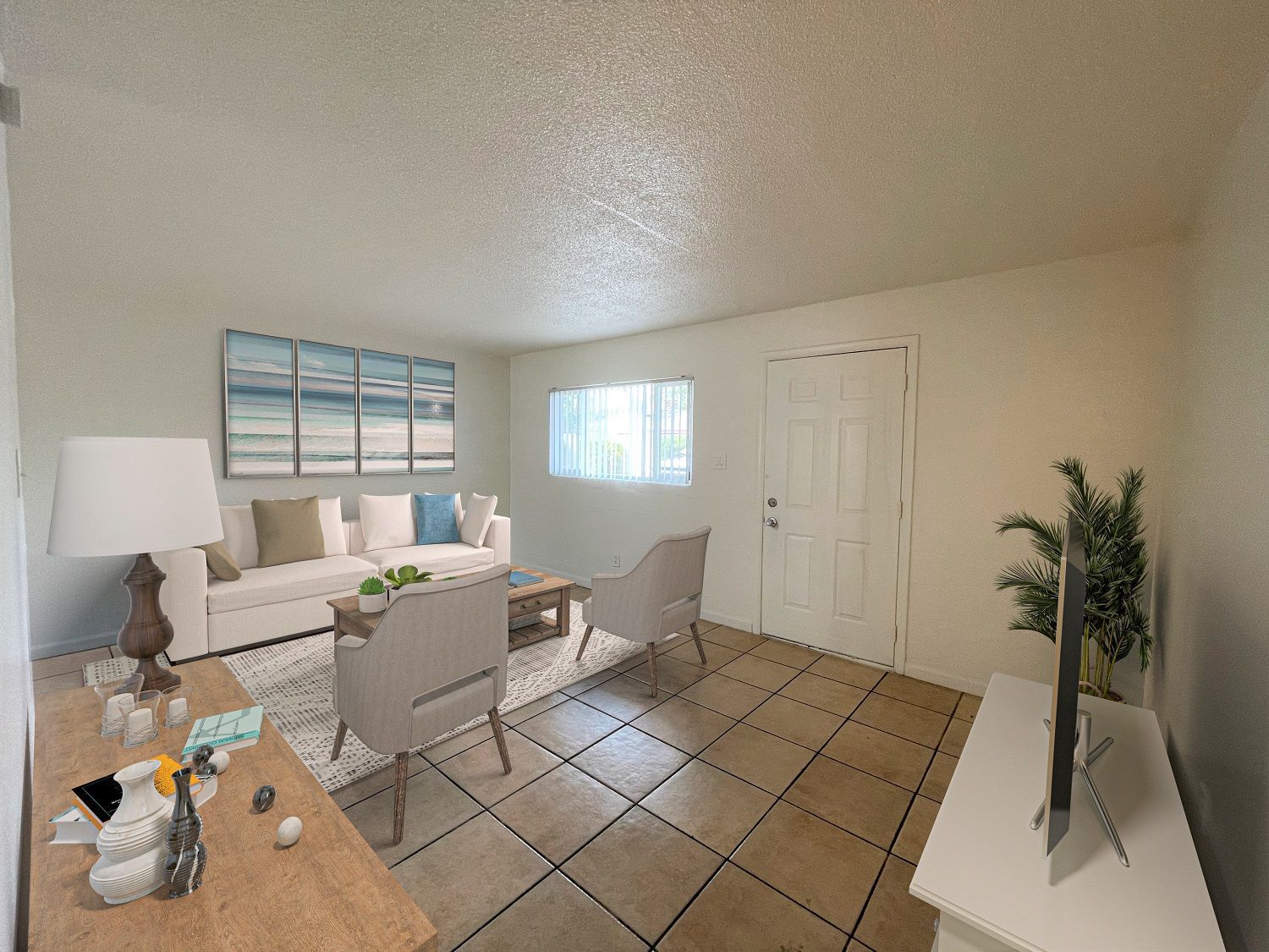 Living room with beige walls, tiled floor, white couch, and TV on a white stand.