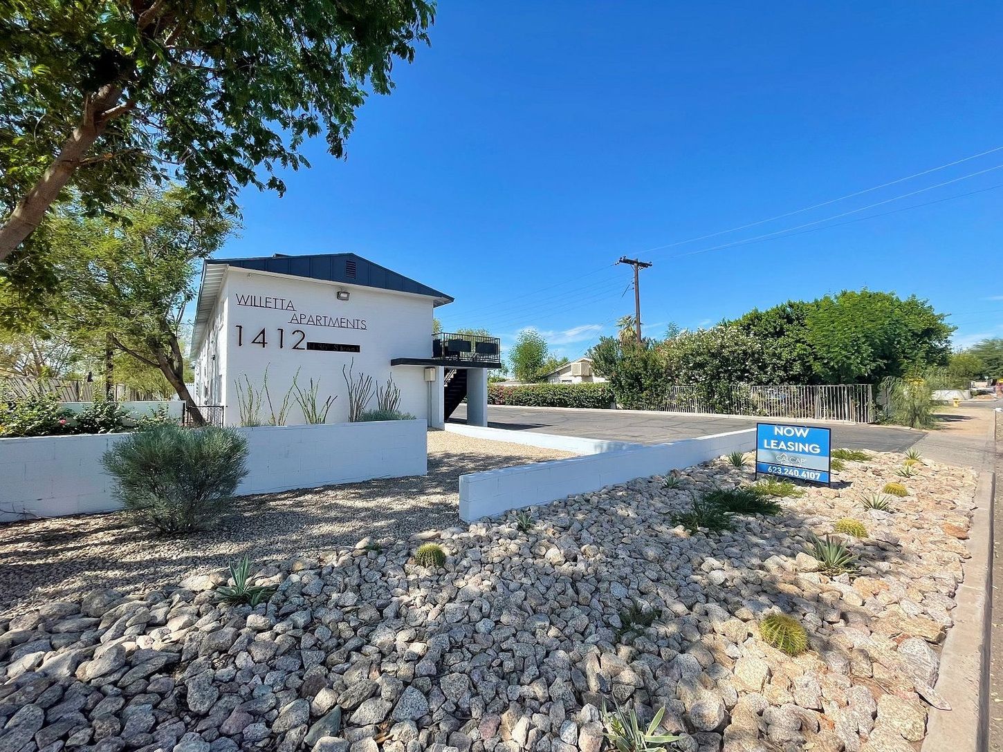 Entrance to Vista Gardens apartments at 1412. White building with black roof and 