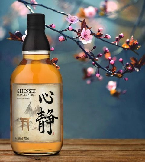 A bottle of shinsei whisky sits on a wooden table