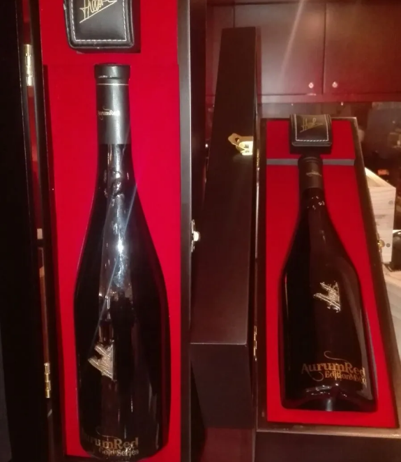 Two bottles of wine are in a black box with a red lining