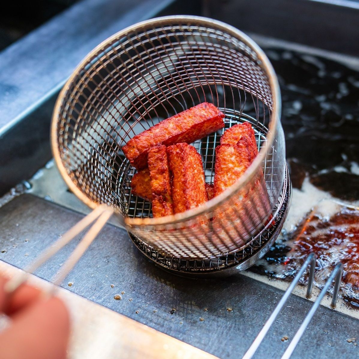 A basket of food is being cooked in a fryer.