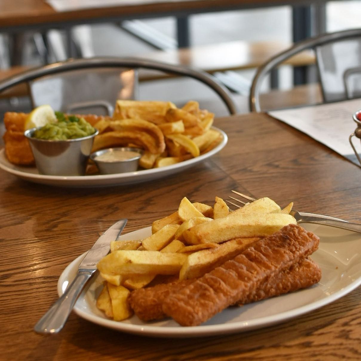 A plate of fish and chips on a wooden table