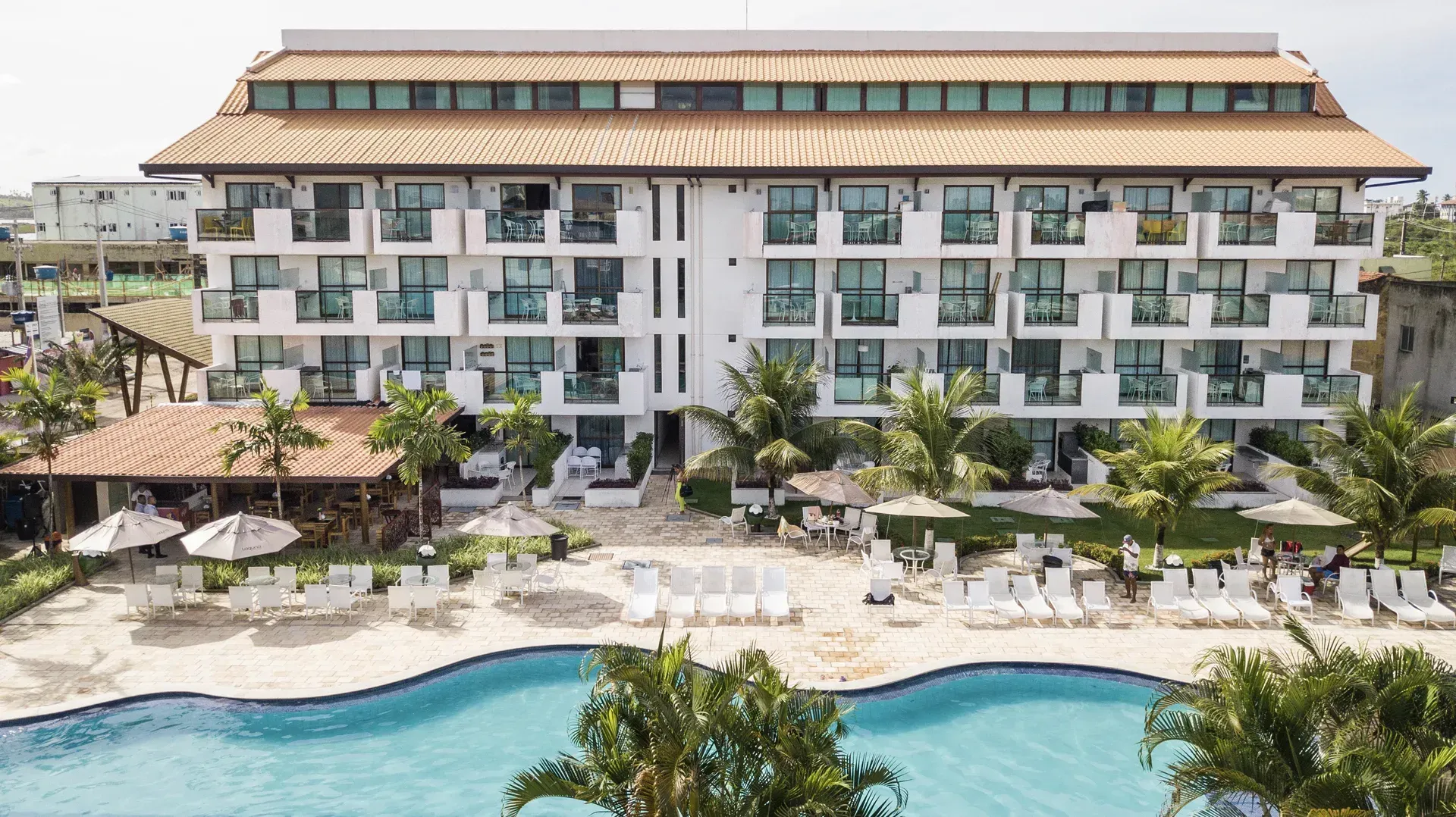 Uma vista aérea de um hotel com uma grande piscina em frente.