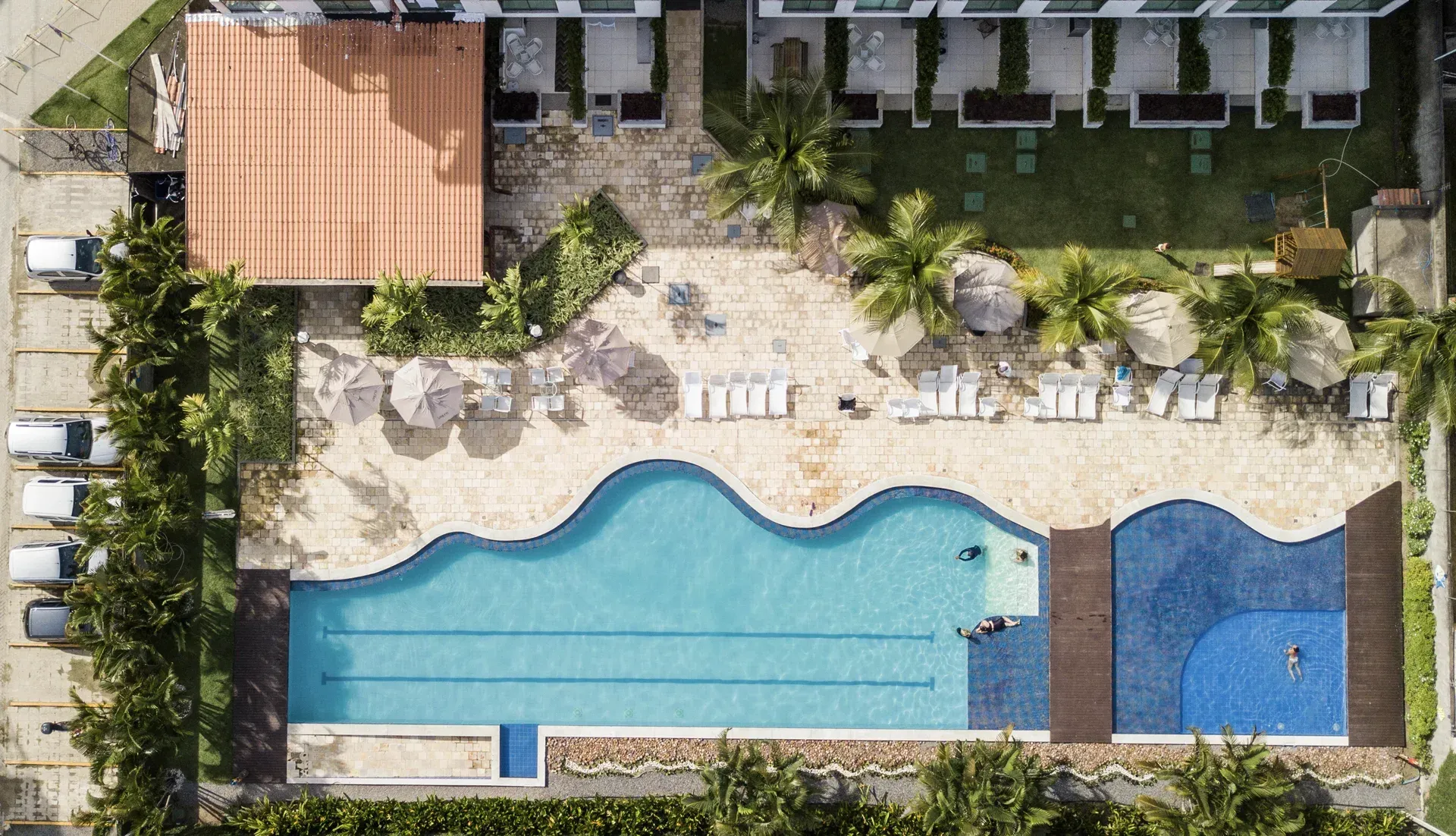 Uma vista aérea de uma grande piscina cercada por palmeiras