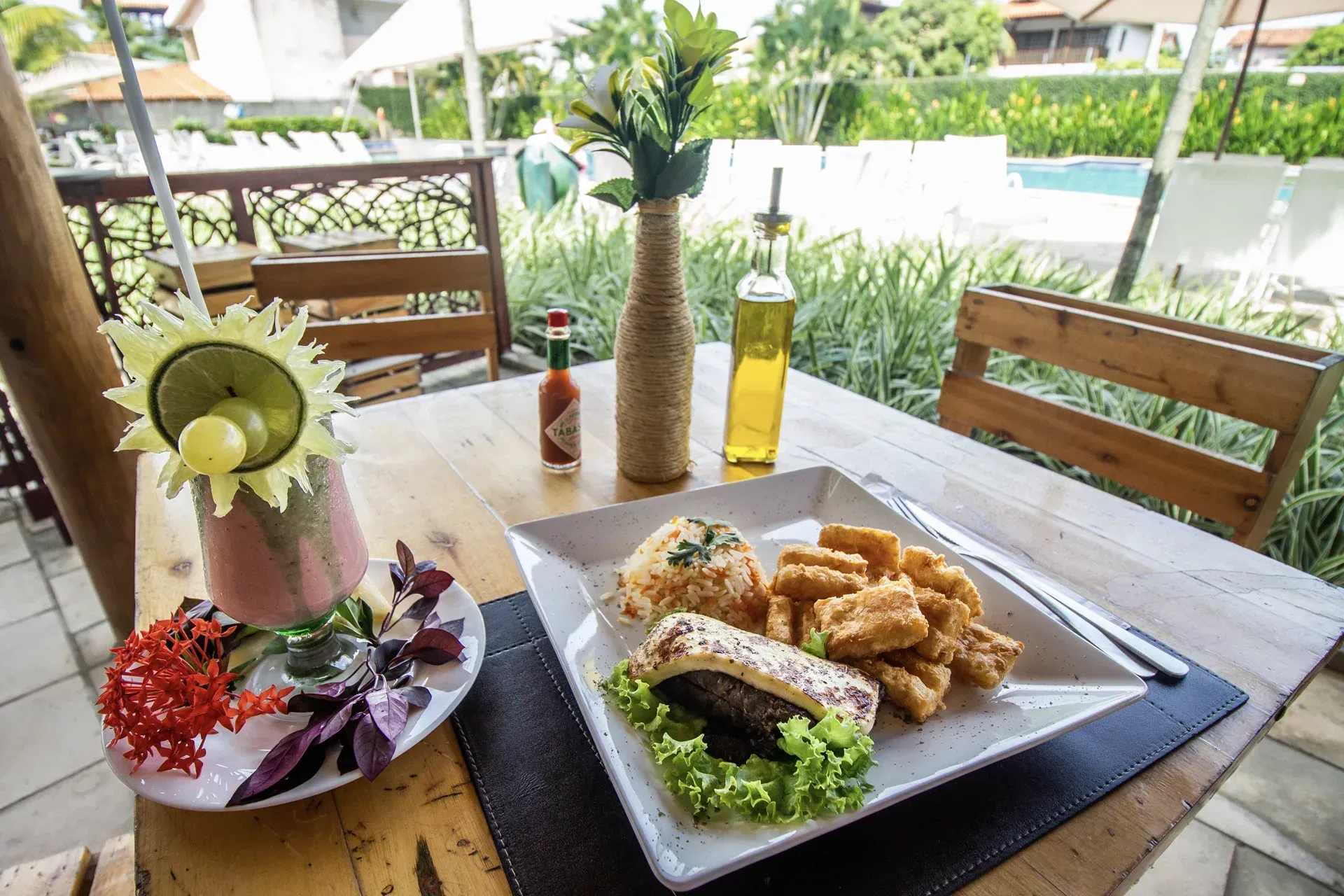 Uma mesa com um prato de comida e uma garrafa de tabasco.
