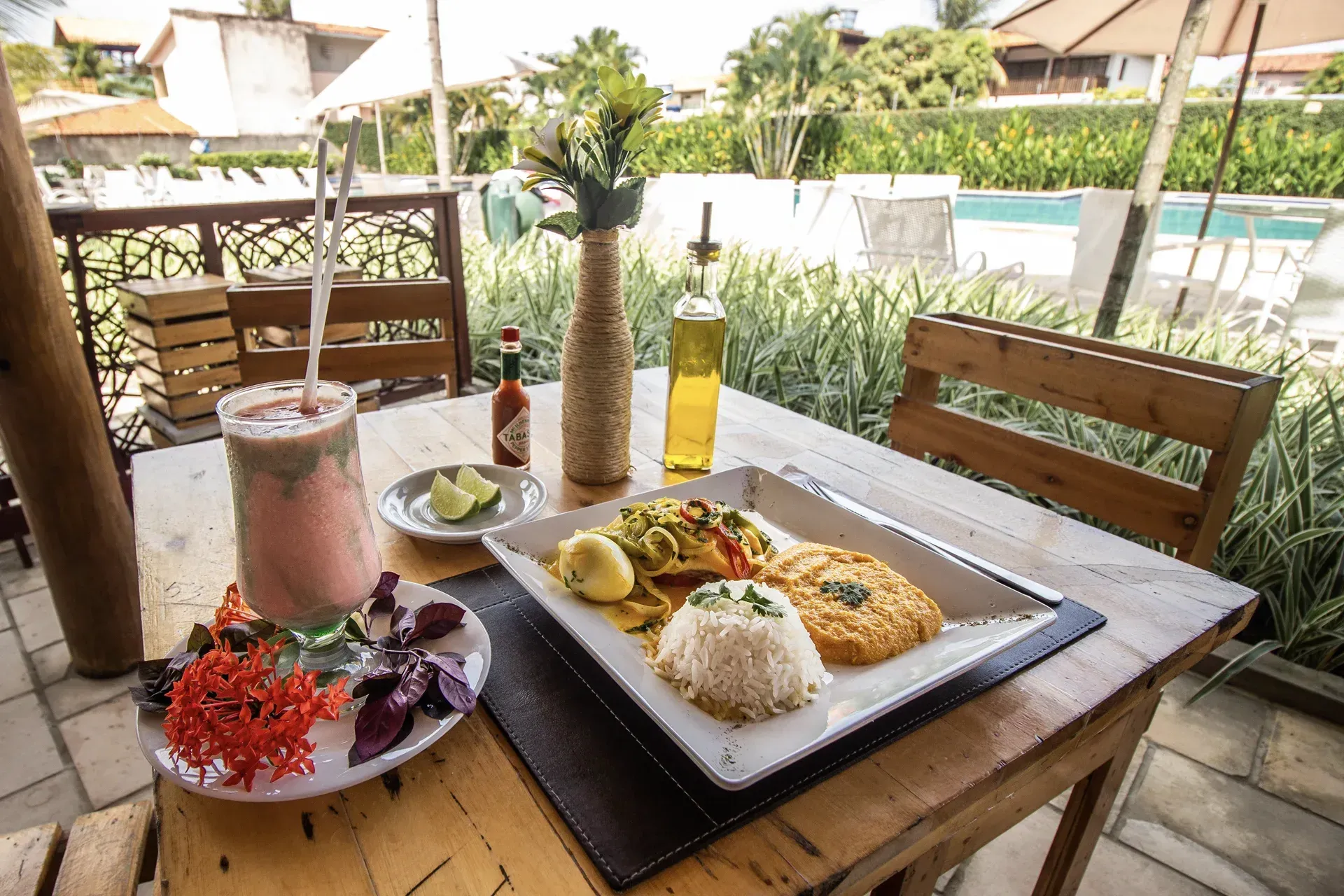 Uma mesa de madeira com pratos de comida e uma bebida.