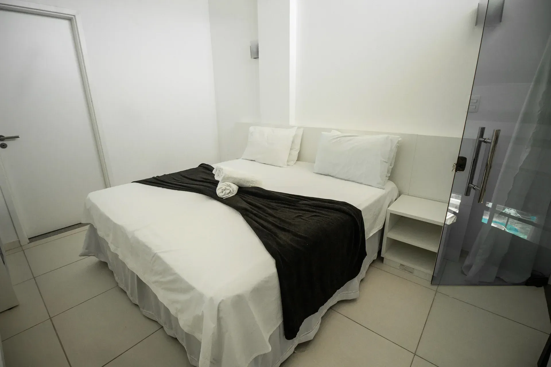 Um quarto de hotel com uma cama e uma mesa de cabeceira