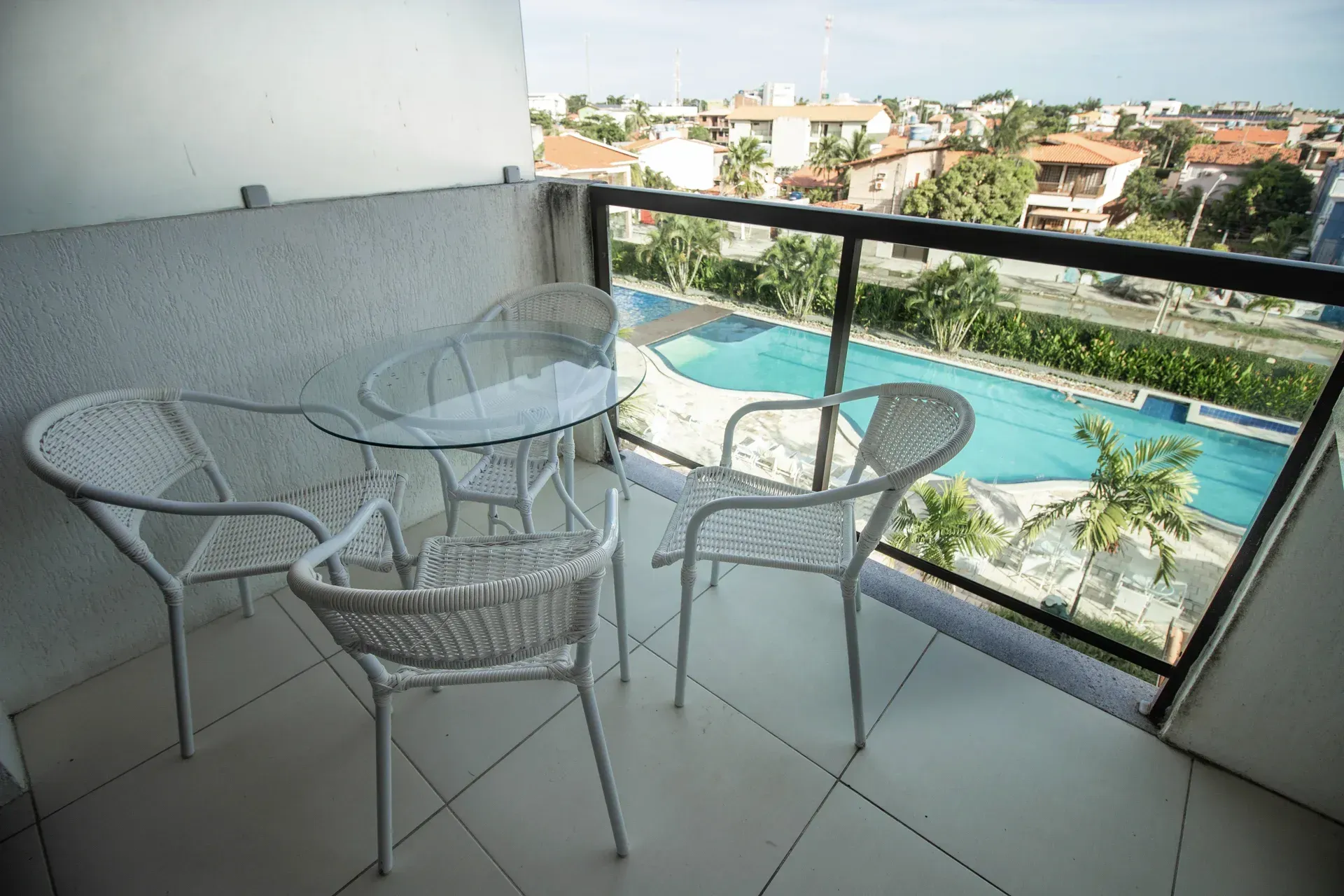 Uma varanda com mesa e cadeiras com vista para a piscina