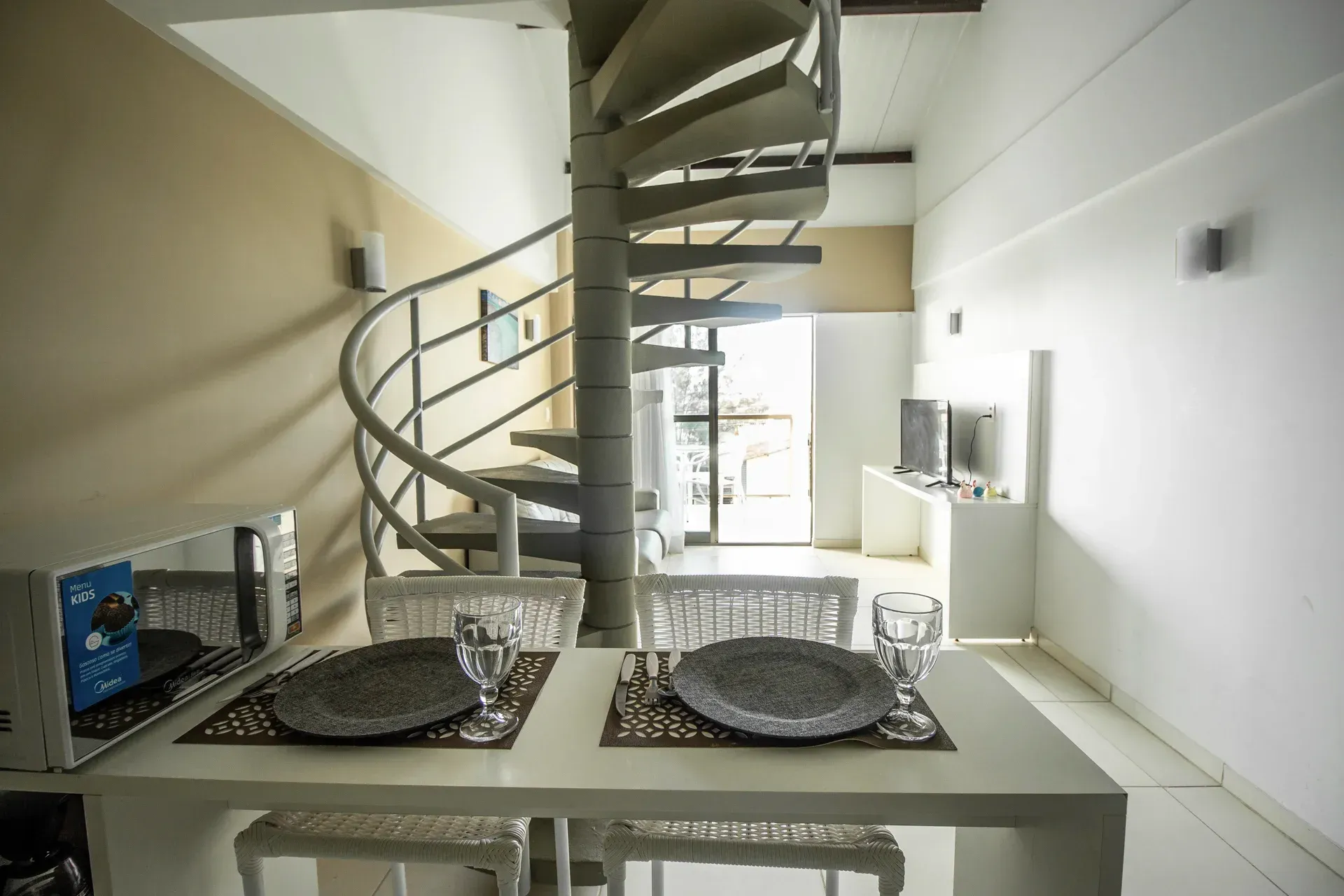 Há uma escada em espiral no meio da sala.