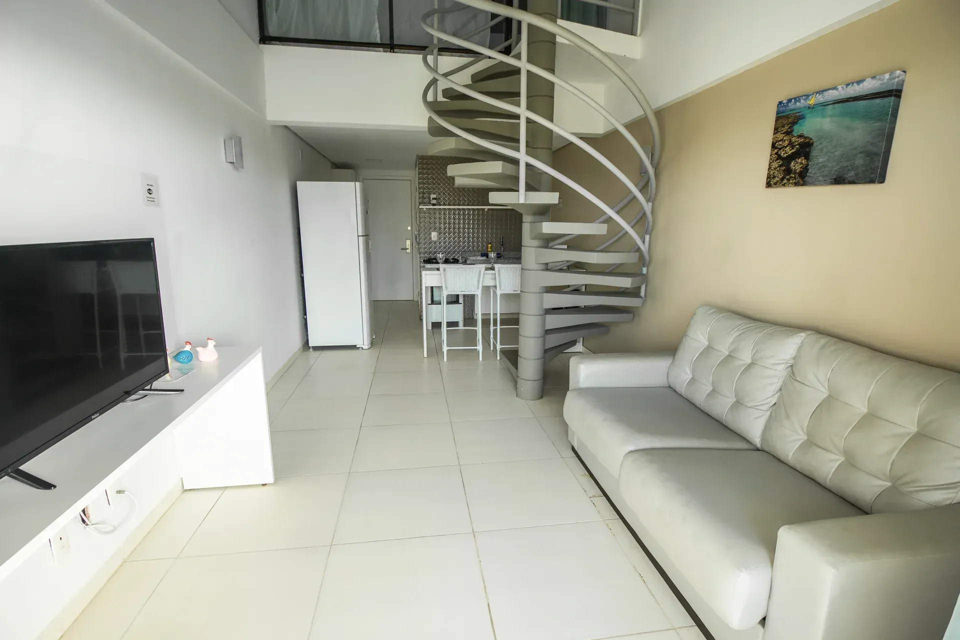 Uma sala de estar com escada em espiral e sofá