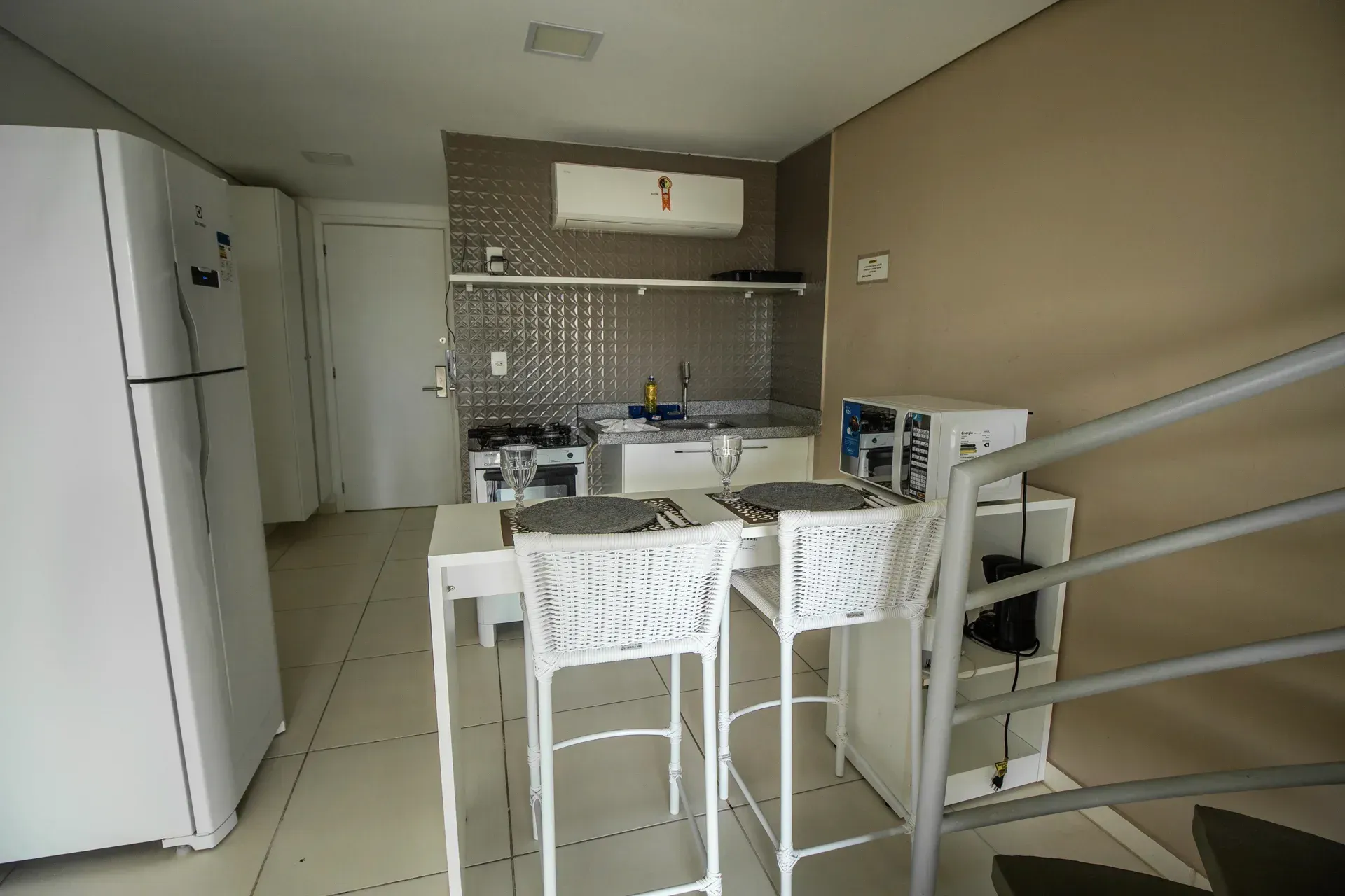 Uma cozinha com mesa e cadeiras e uma geladeira