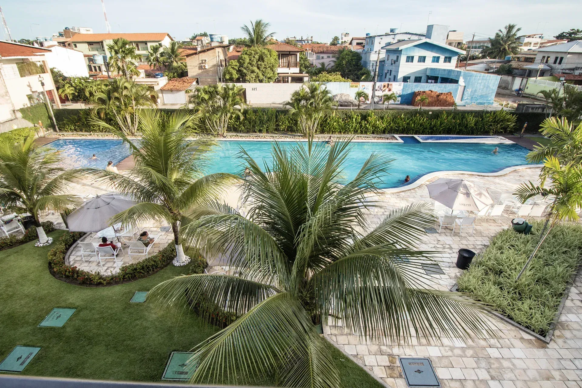 Uma vista aérea de uma piscina cercada por palmeiras