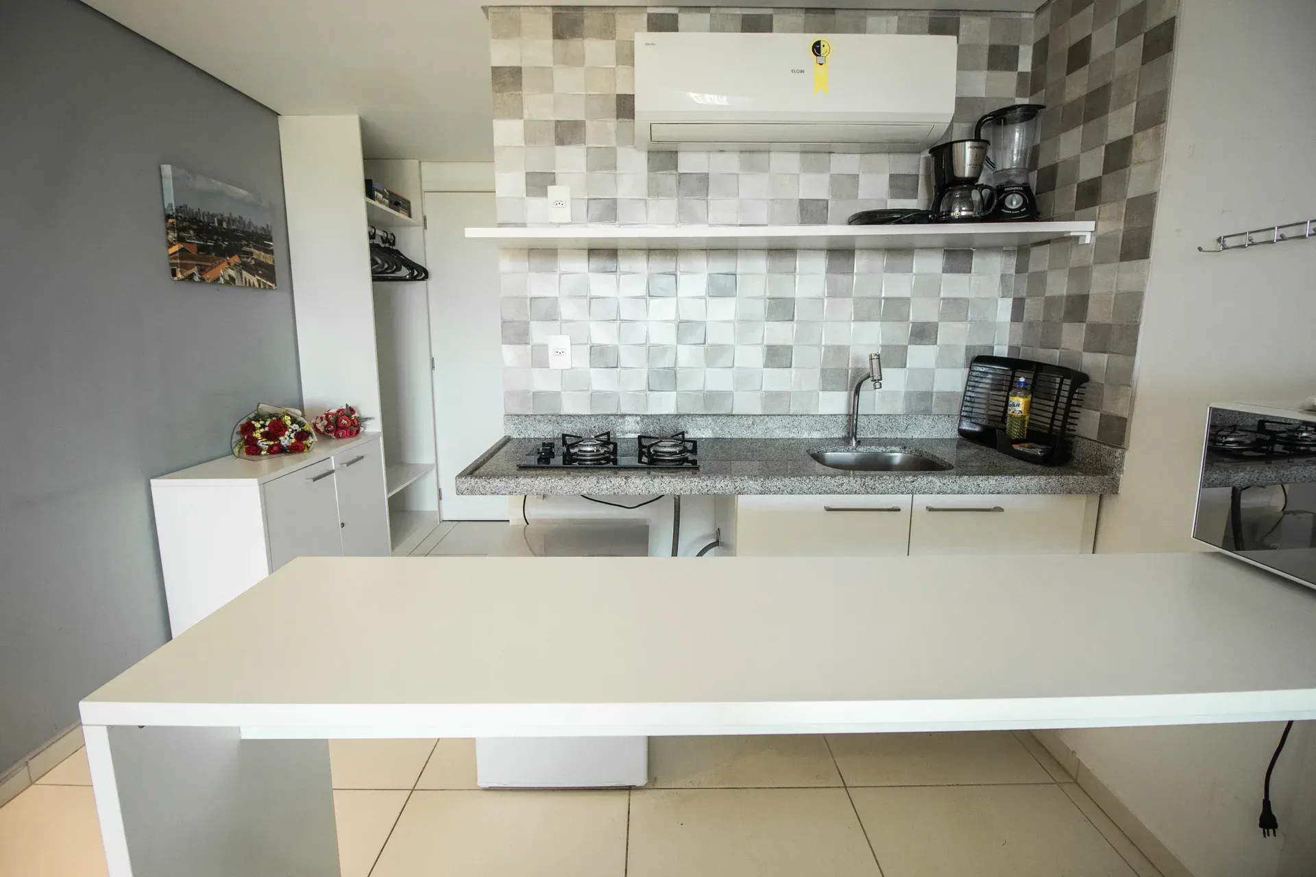 Uma cozinha com uma grande mesa branca e um fogão.