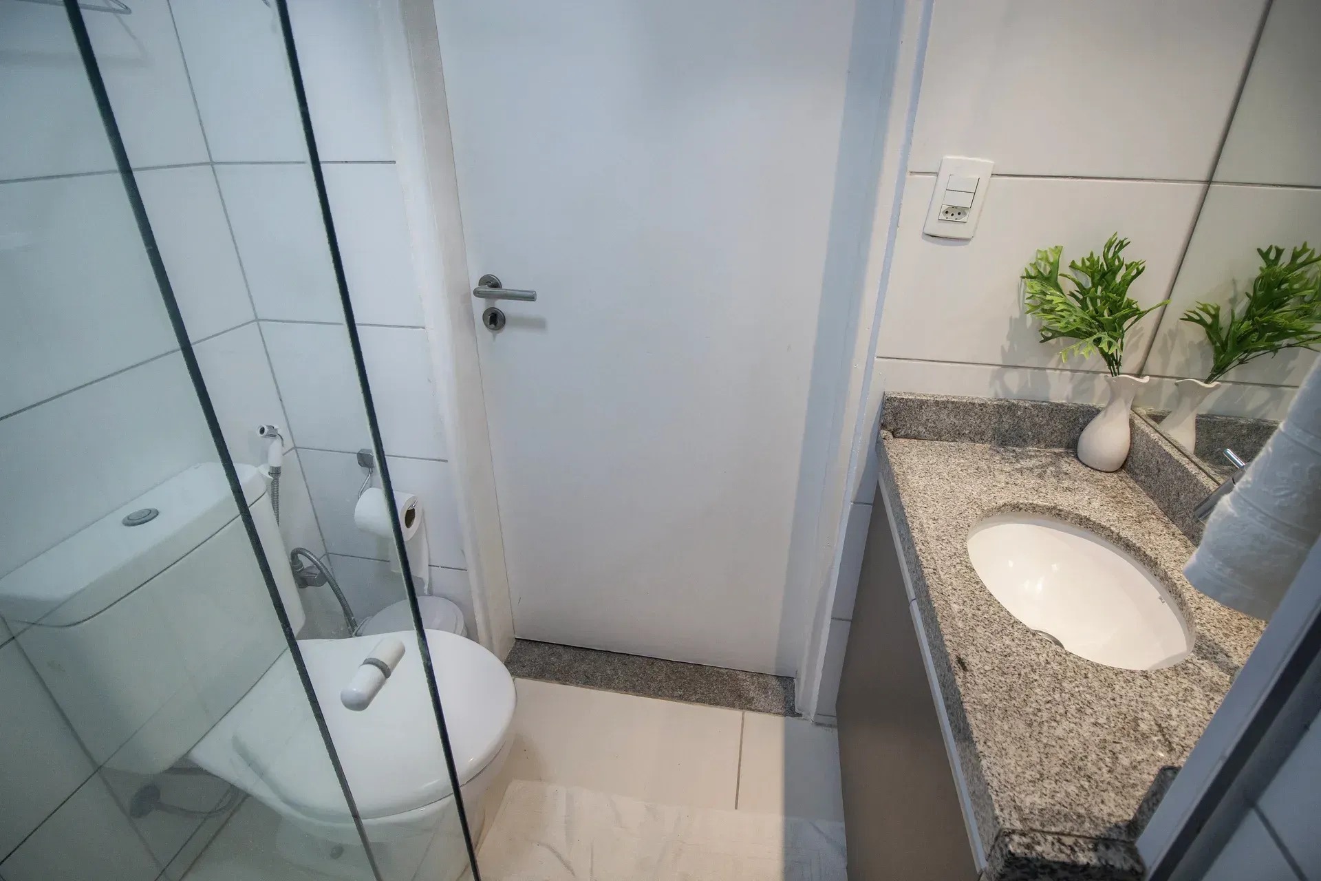 Um banheiro com vaso sanitário, pia e chuveiro.