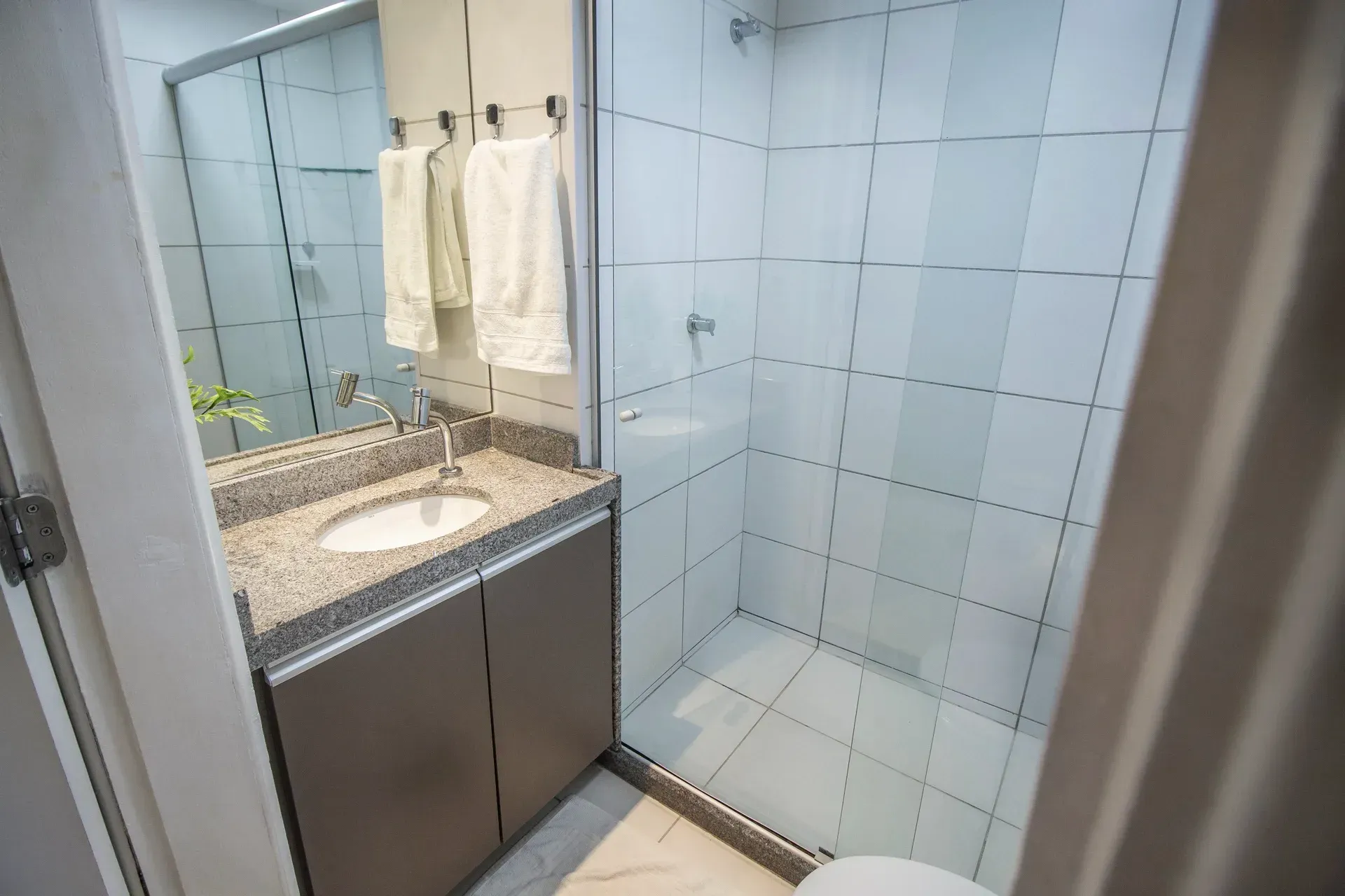 Um banheiro com pia, vaso sanitário e chuveiro.