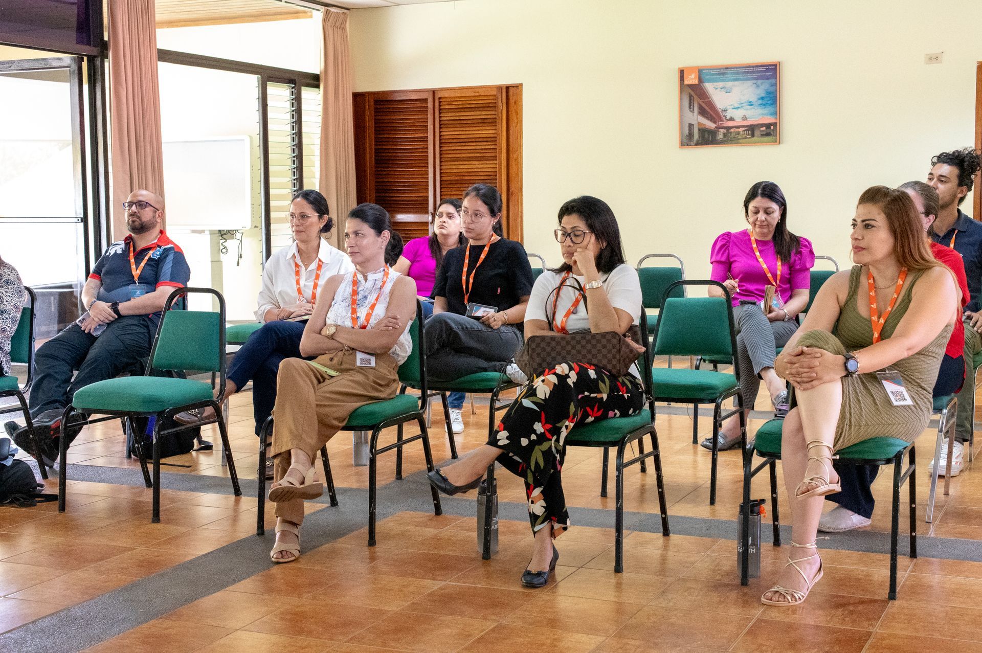 Un grupo de personas están sentadas en sillas en una habitación.
