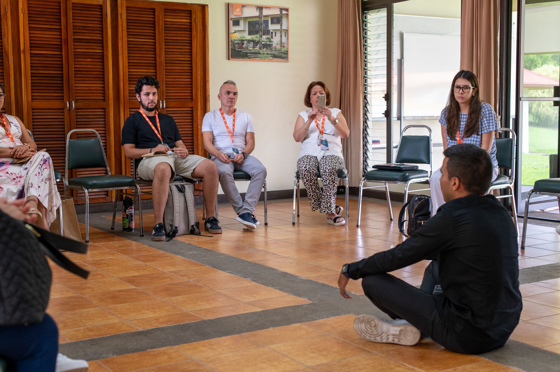 Un grupo de personas está sentada alrededor de un hombre sentado en el suelo.