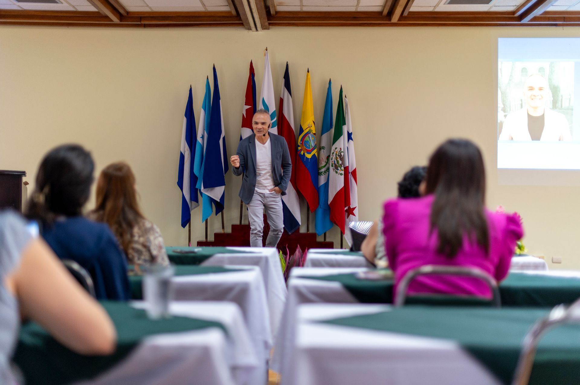 Un hombre está dando una presentación a un grupo de personas en una sala de conferencias.
