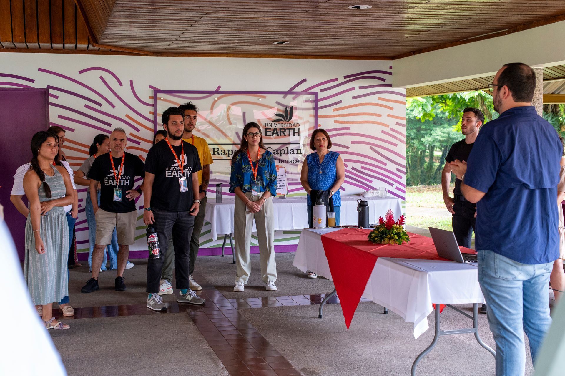 Un grupo de personas están de pie alrededor de una mesa en una habitación.