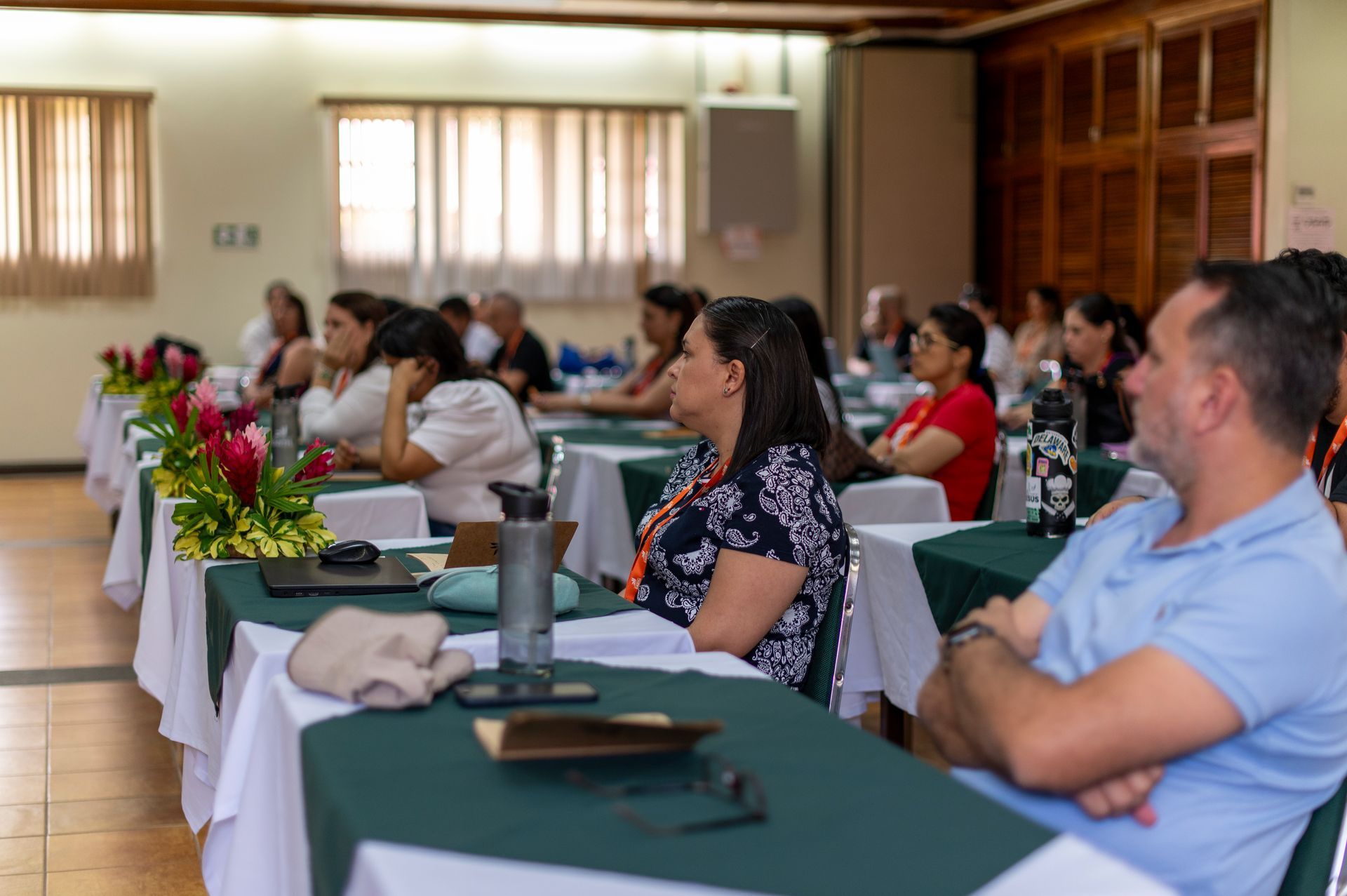 Un grupo de personas están sentadas en mesas en una habitación.