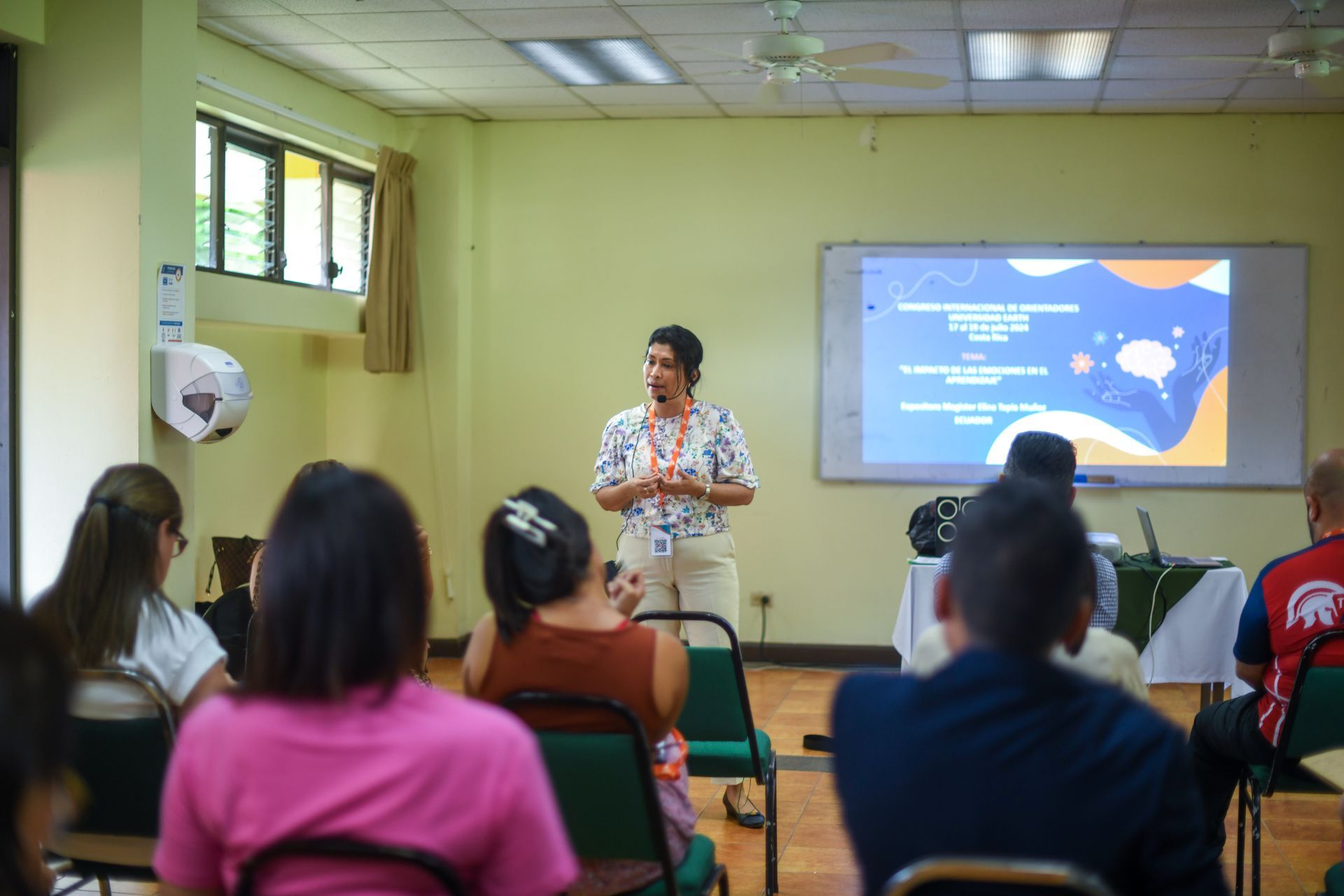Una mujer está dando una presentación a un grupo de personas en una habitación.