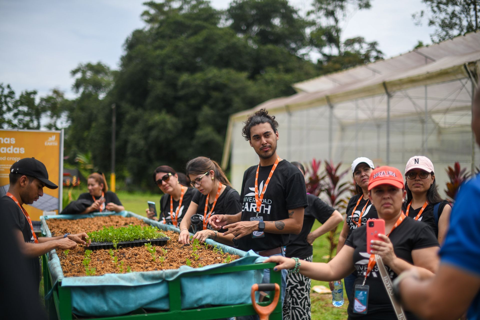 Un grupo de personas está de pie alrededor de un invernadero.