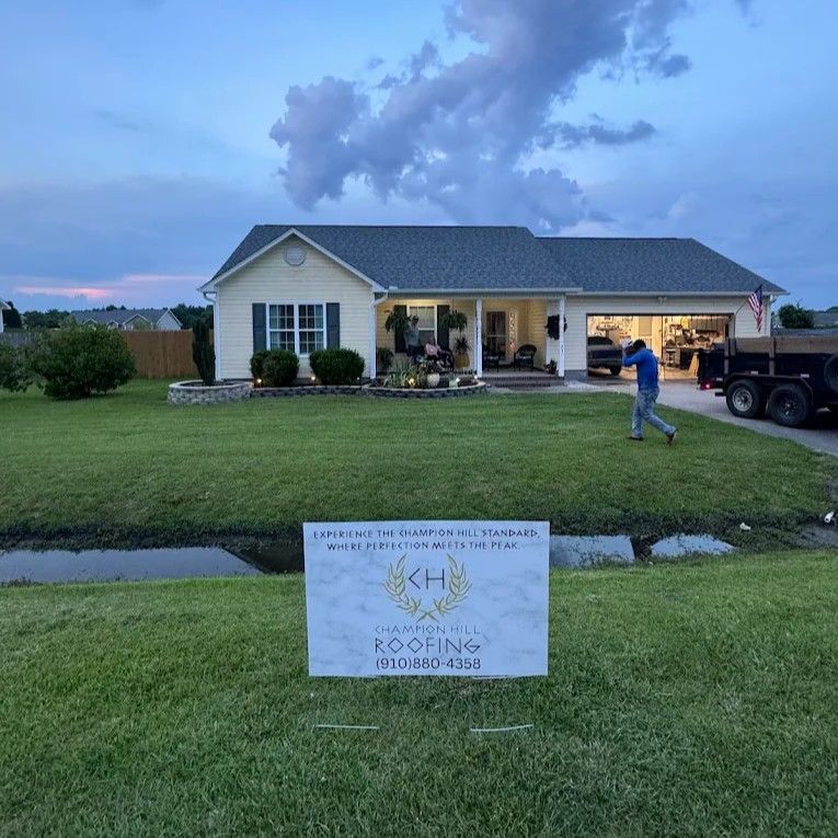 A house with new roofing, a worker, and a sign for CH Roofing.
