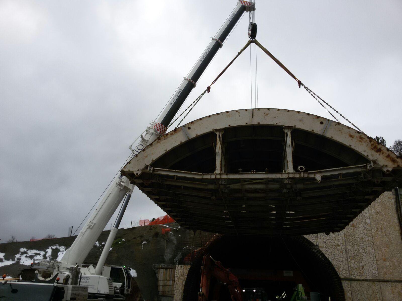 Una gru sta sollevando un grande pezzo di metallo in un tunnel