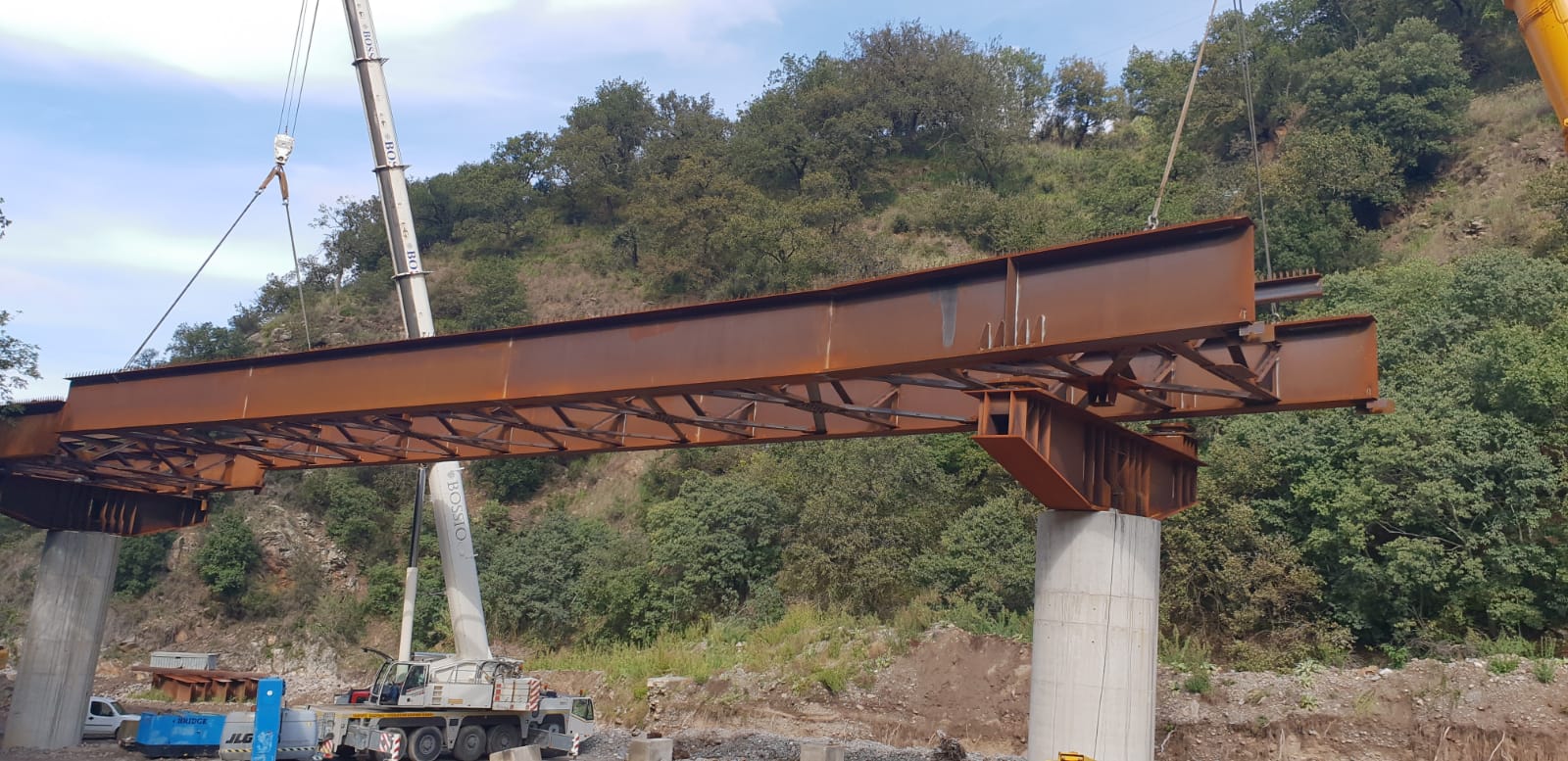 Si sta costruendo un ponte sopra un fiume con una gru.