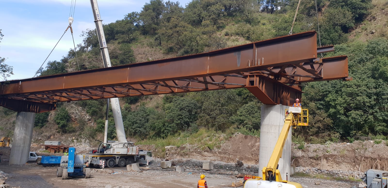 Si sta costruendo un ponte sopra un fiume con una gru.