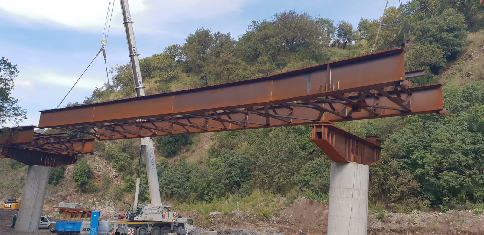 Una grande struttura metallica viene sollevata da una gru.