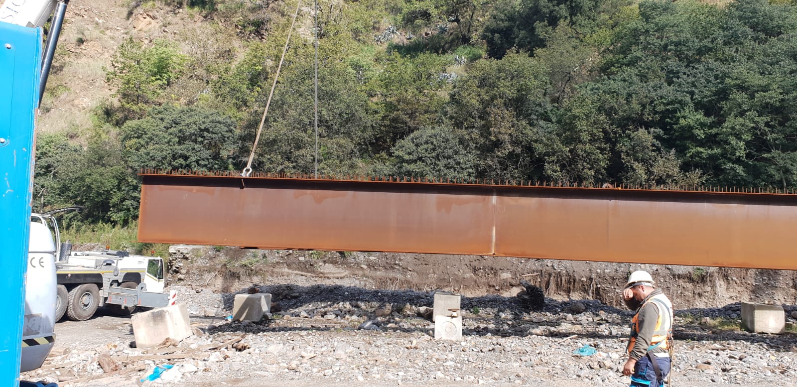 Un uomo è in piedi accanto a un grosso pezzo di metallo.