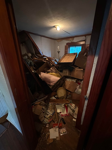 A moving truck filled with boxes , baskets , and other items.