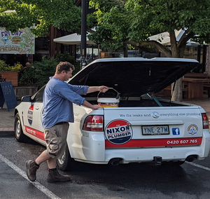 A man is opening the trunk of a nixon truck
