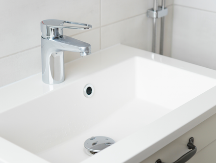 A bathroom sink with a chrome faucet on top of it.