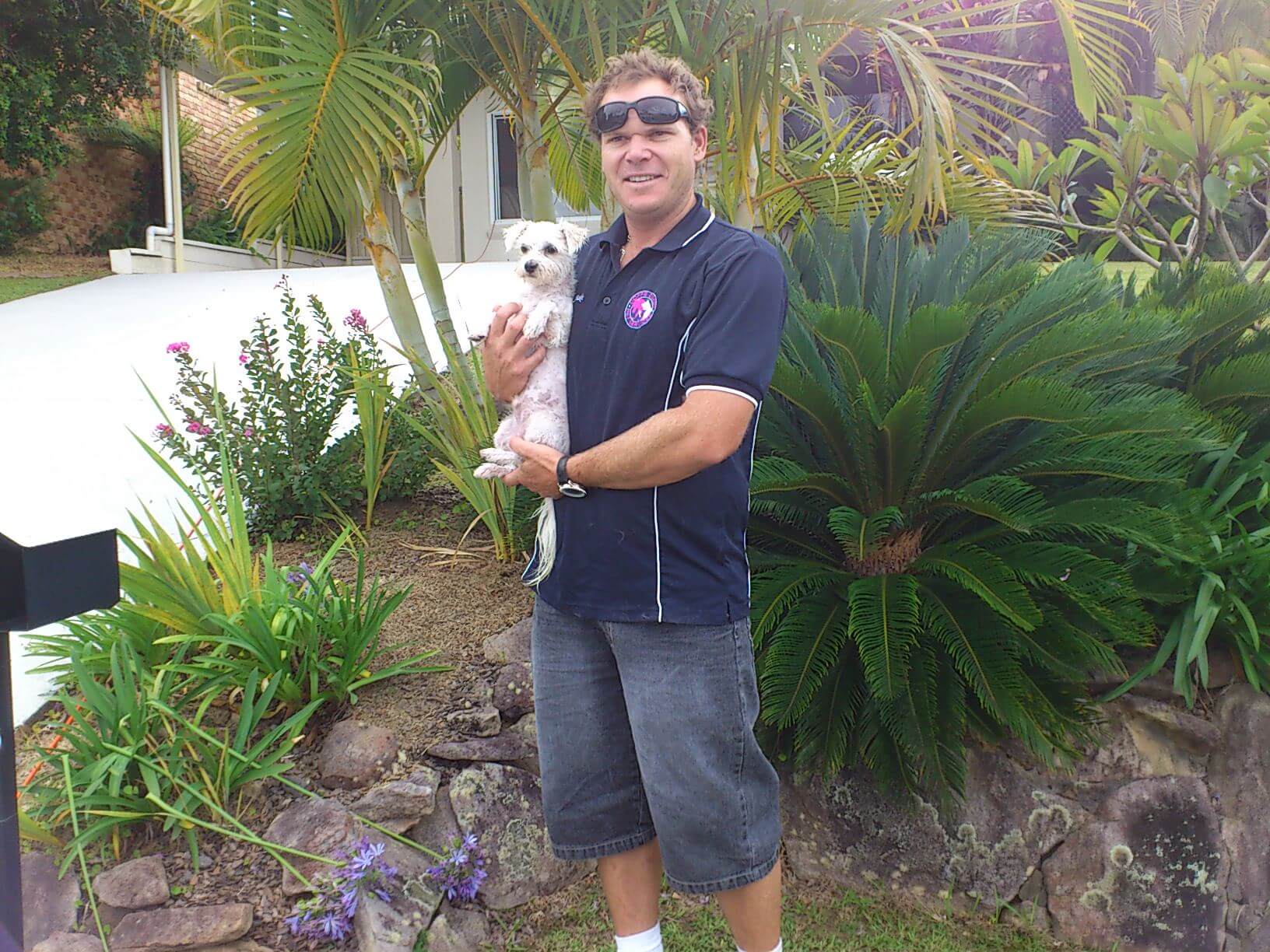 Man Carrying Little Dog — Coffs Coast Pet Services in Coffs Harbour, NSW