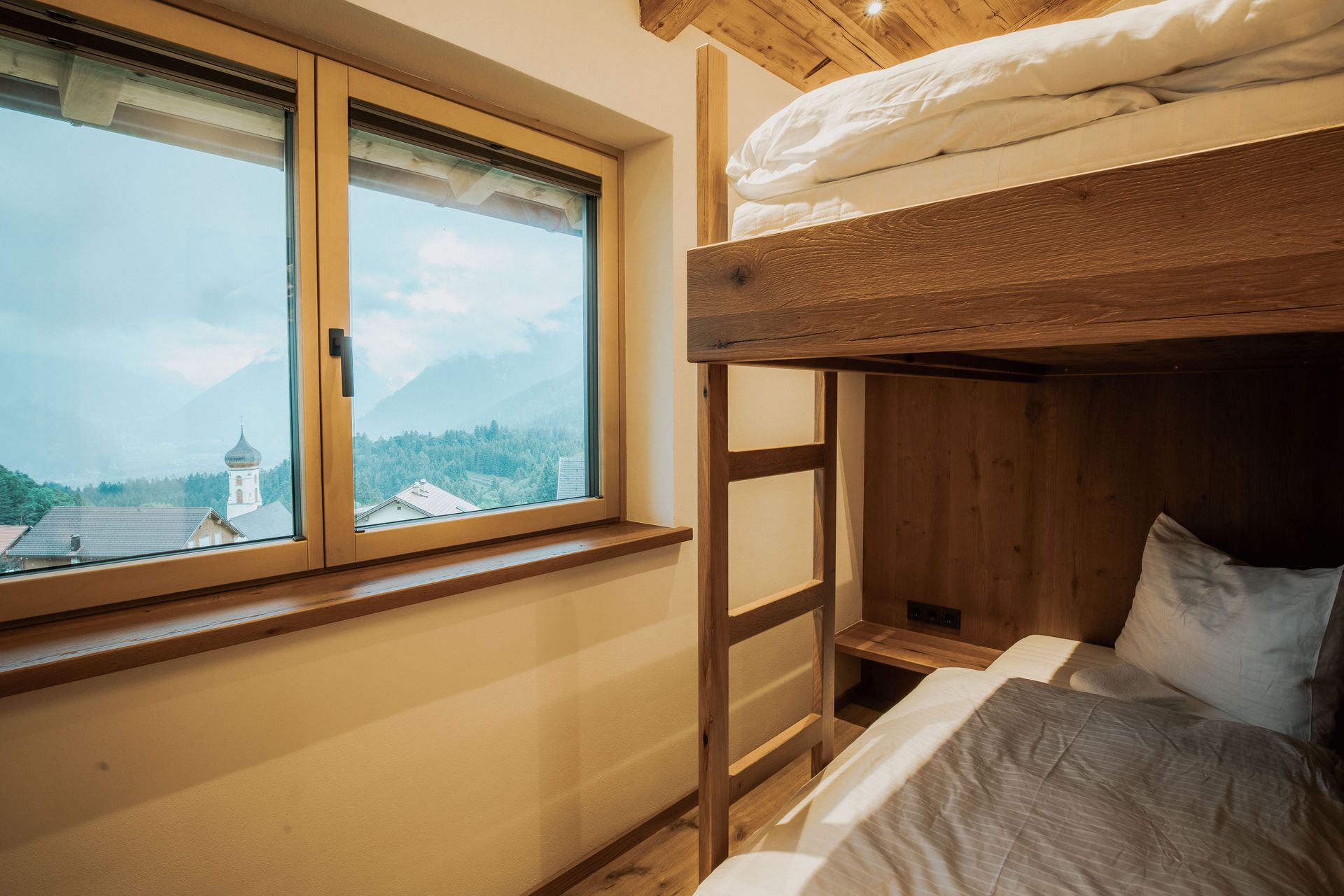 Im Zimmer mit Fenster steht ein Etagenbett.