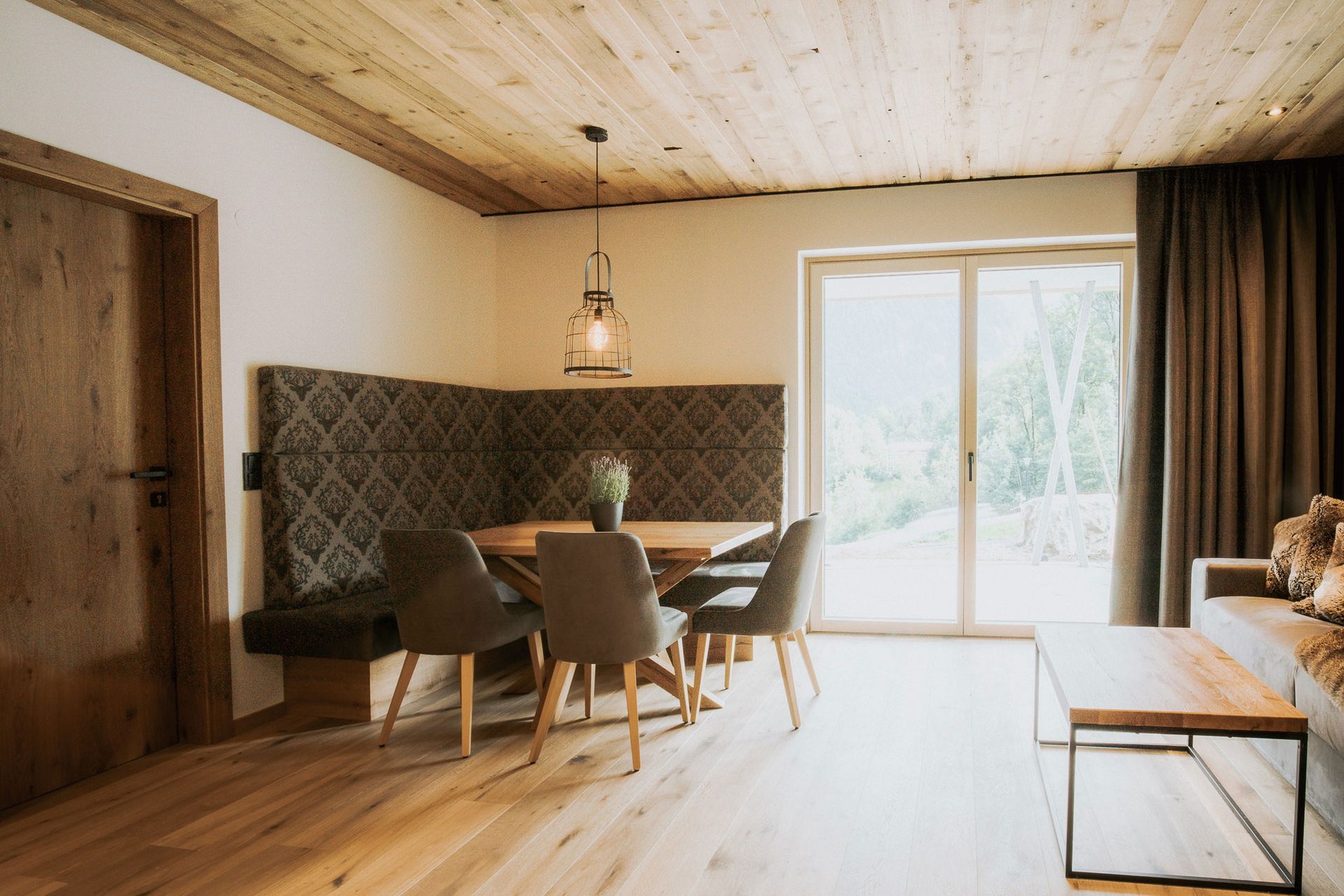 Ein Wohnzimmer mit Tisch und Stühlen und einem großen Fenster.