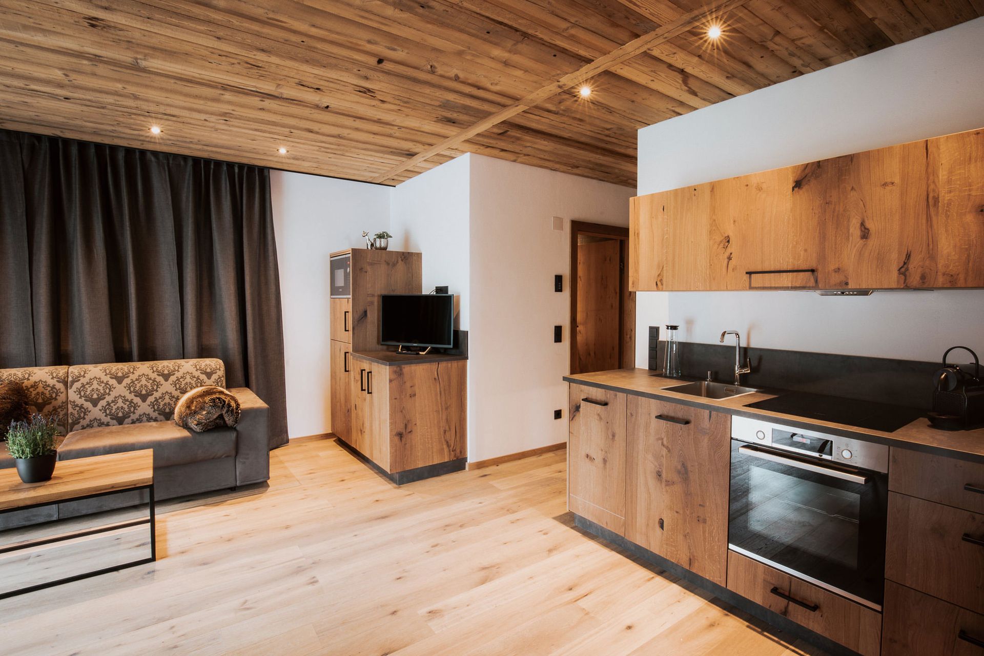 Ein Wohnzimmer mit Couch und eine Küche mit Holzschränken.