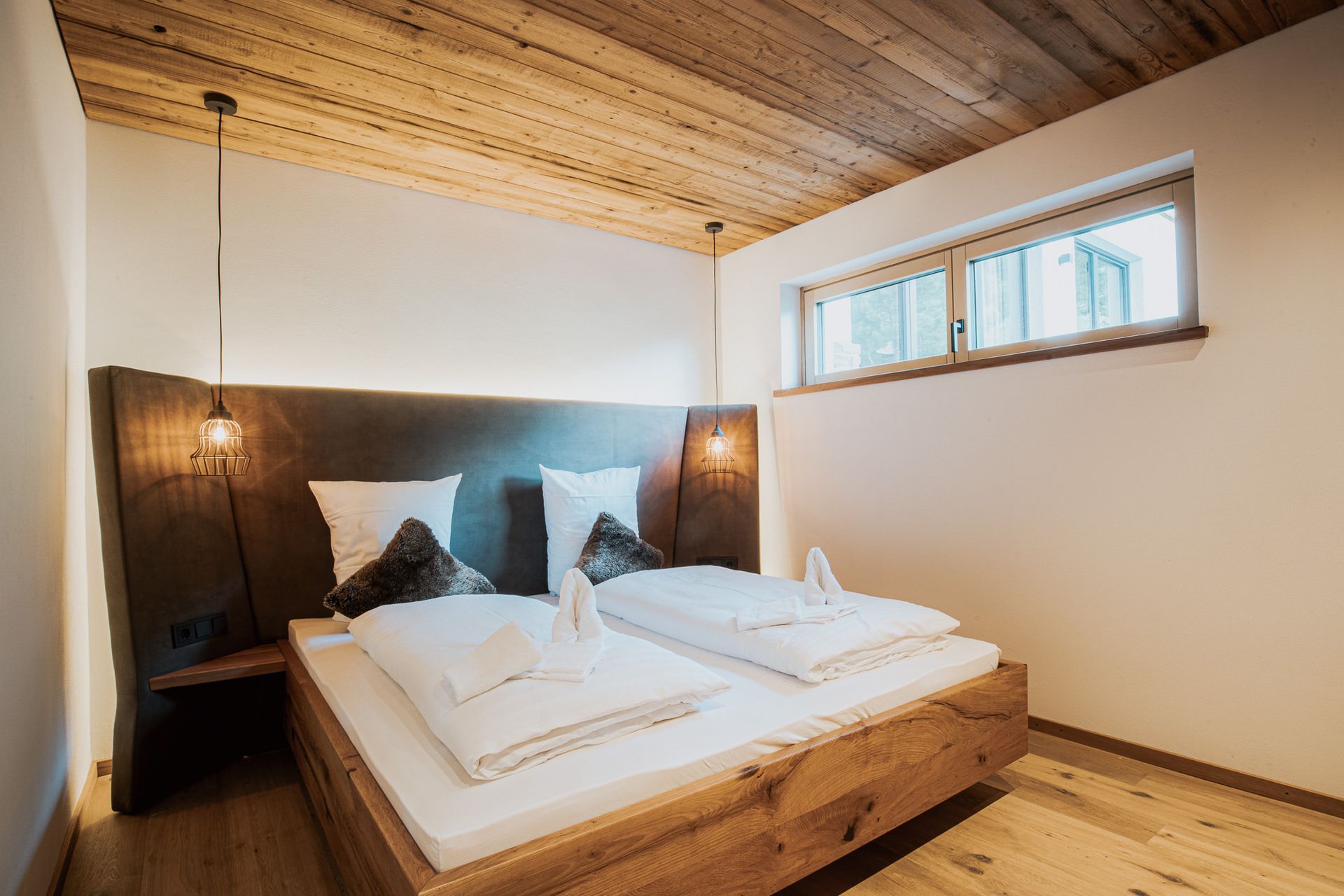 Ein Schlafzimmer mit einem Holzbett und einem Fenster.