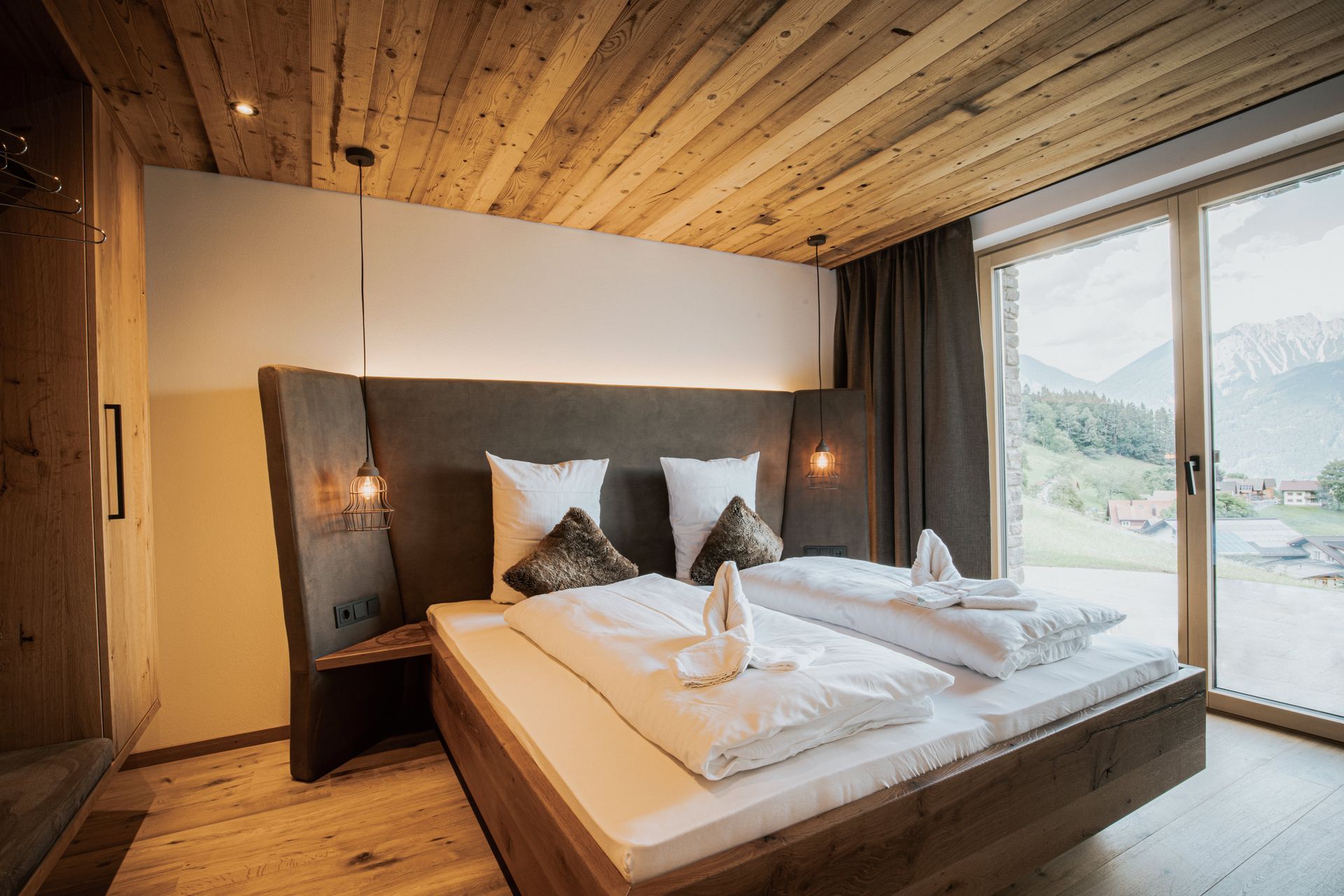 Ein Schlafzimmer mit großem Bett und Glasschiebetür.