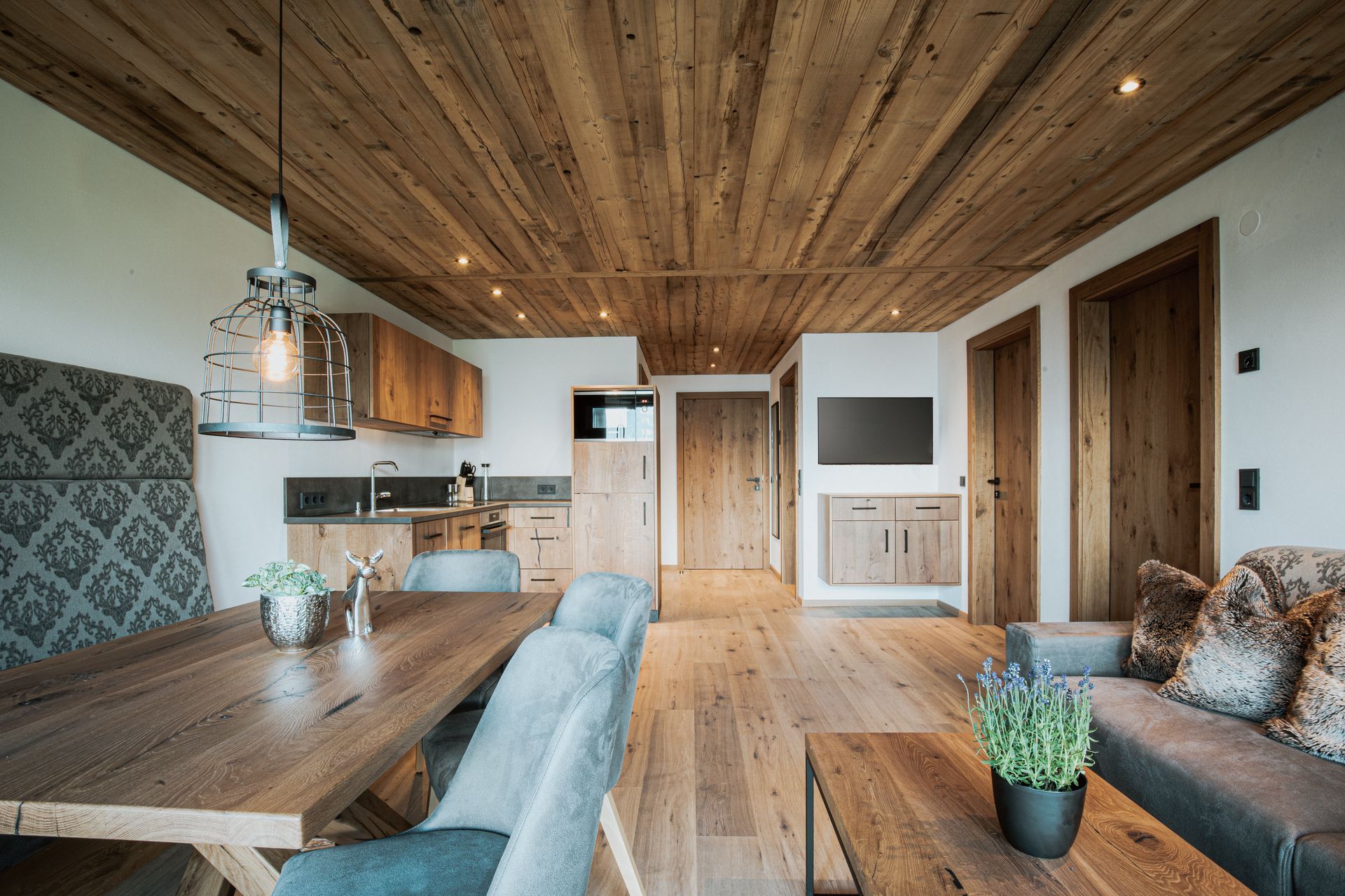 Ein Wohnzimmer mit einem Holztisch und Stühlen und einer Holzdecke.