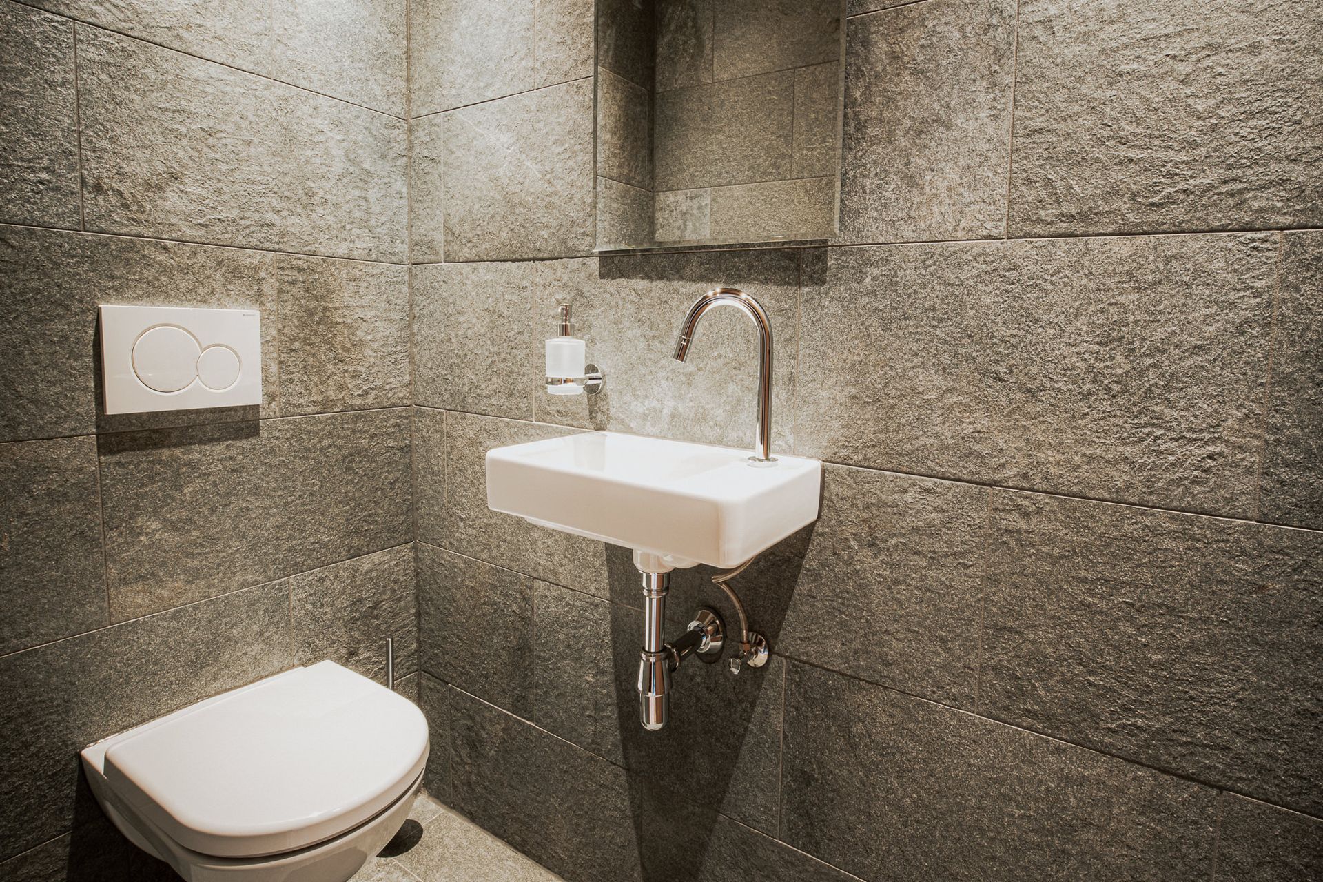 Ein Badezimmer mit Toilette, Waschbecken und Spiegel.