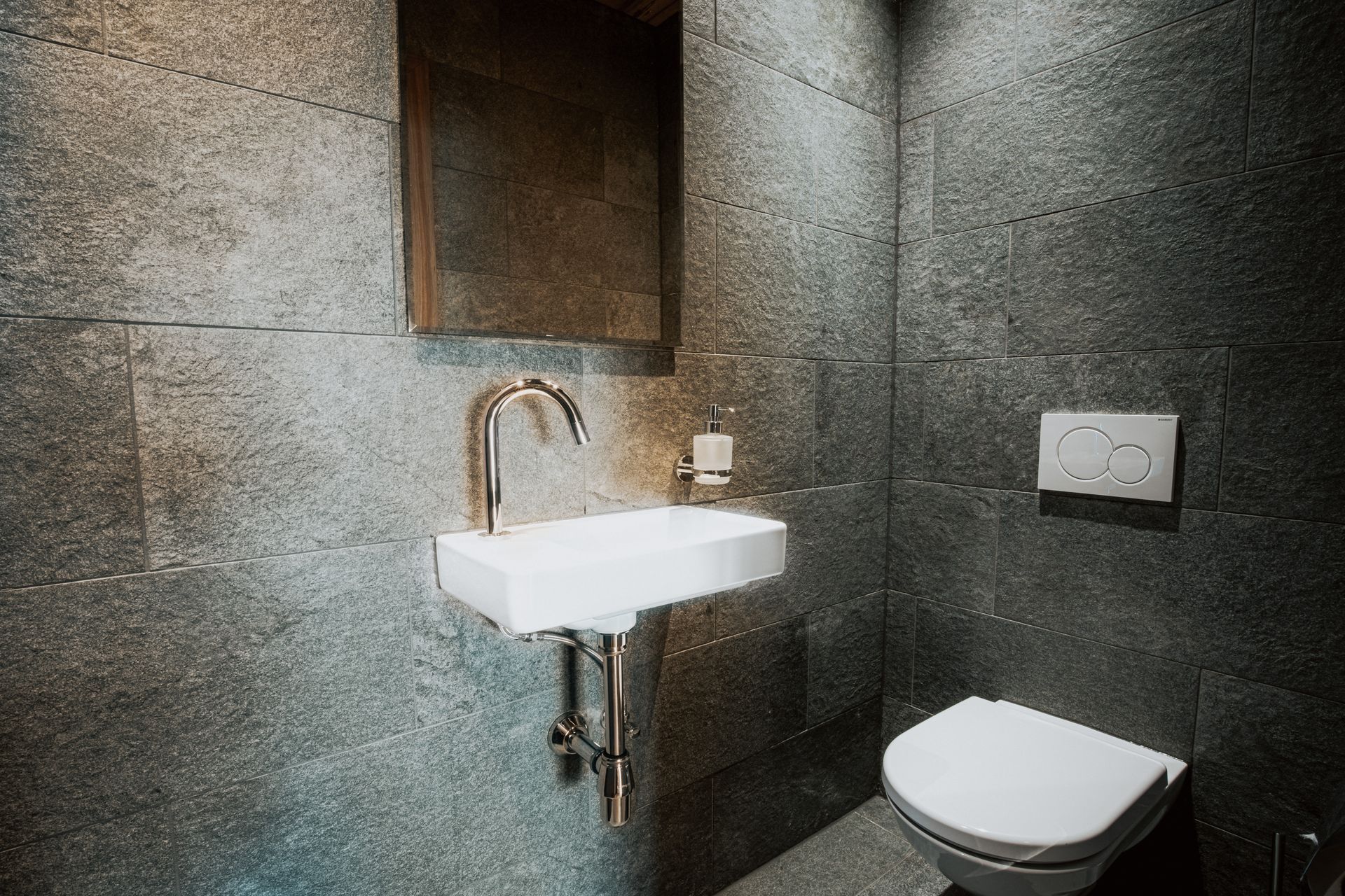 Ein Badezimmer mit Toilette, Waschbecken und Spiegel.