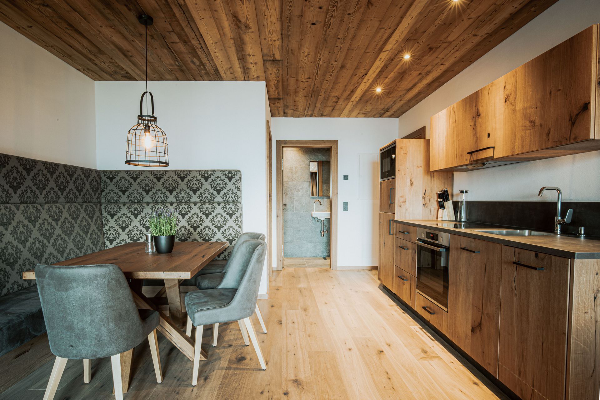 Eine Küche mit Holzschränken, einem Tisch und Stühlen.