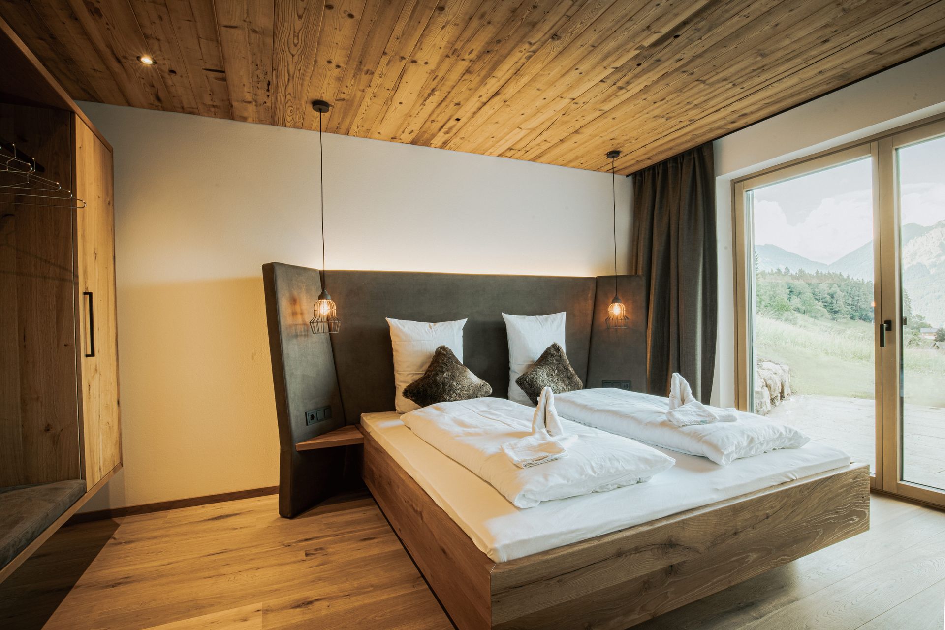 Ein Schlafzimmer mit großem Bett und Glasschiebetür.