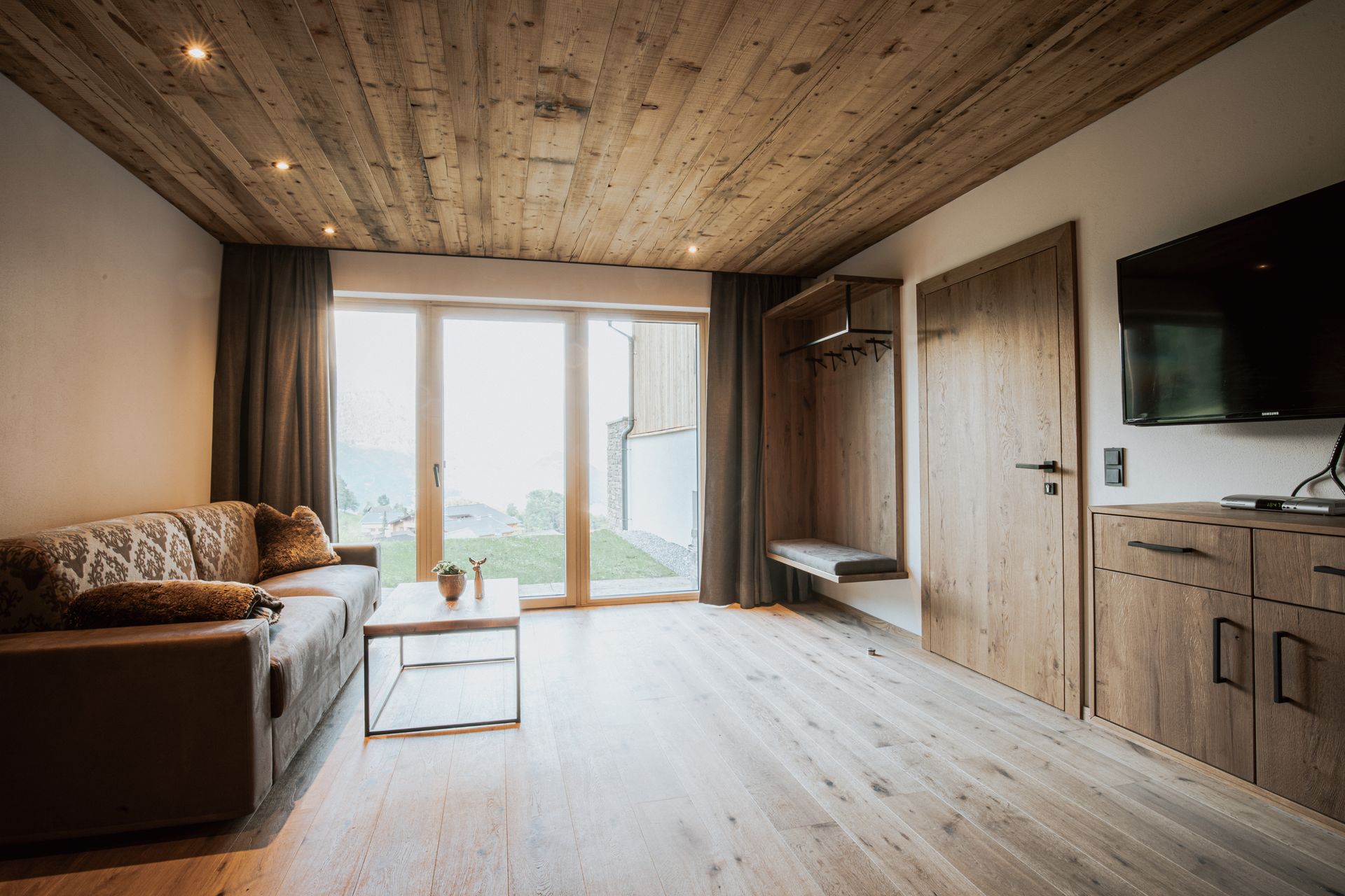 Ein Wohnzimmer mit Couch, Tisch und Fernseher.