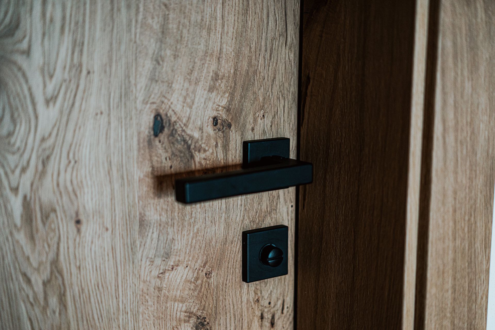Eine Nahaufnahme einer Holztür mit einem schwarzen Griff.